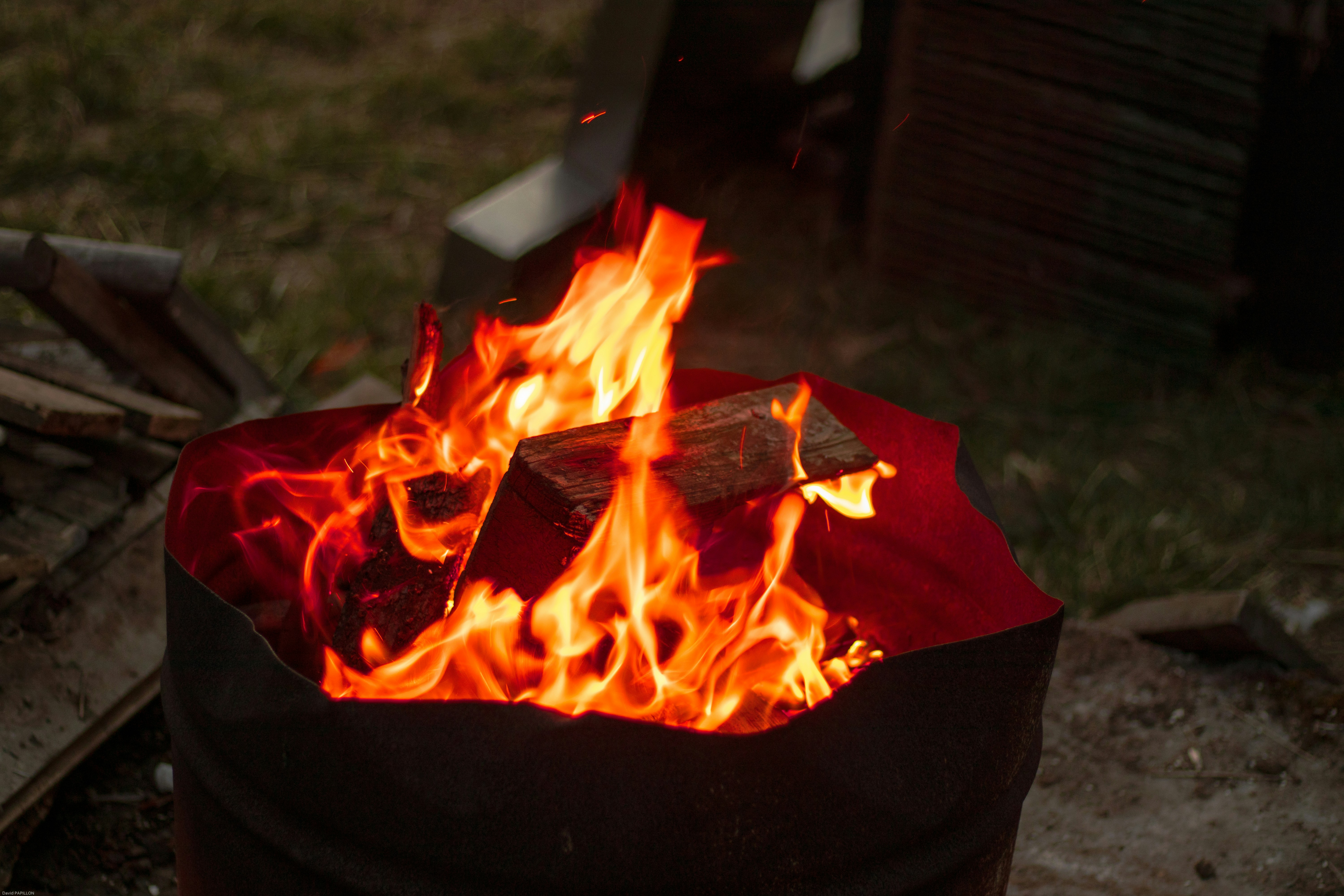 Leña quemando en un barril metálico
