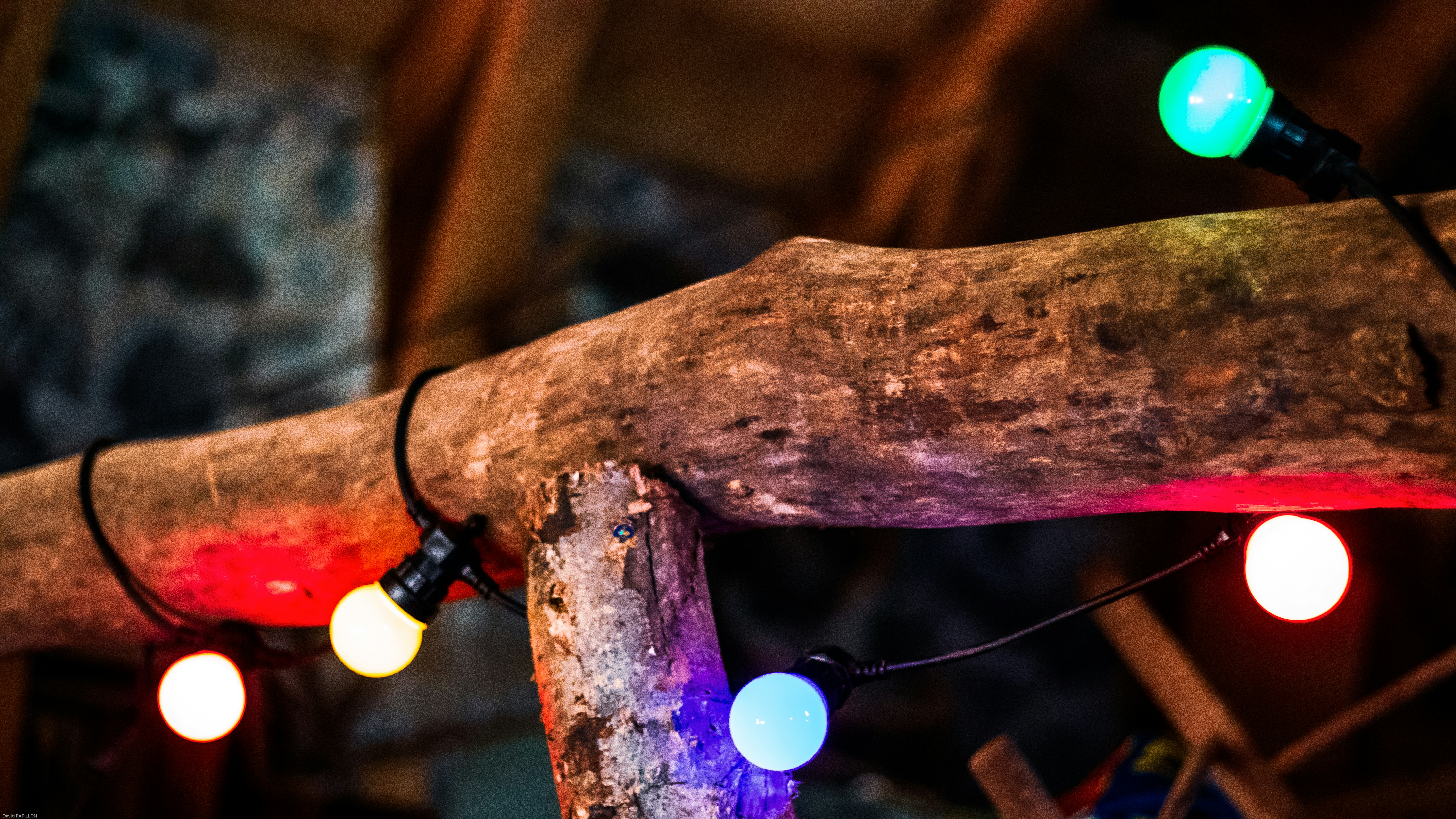 Luces de hilo de colores colgaban sobre vigas rústicas de madera.