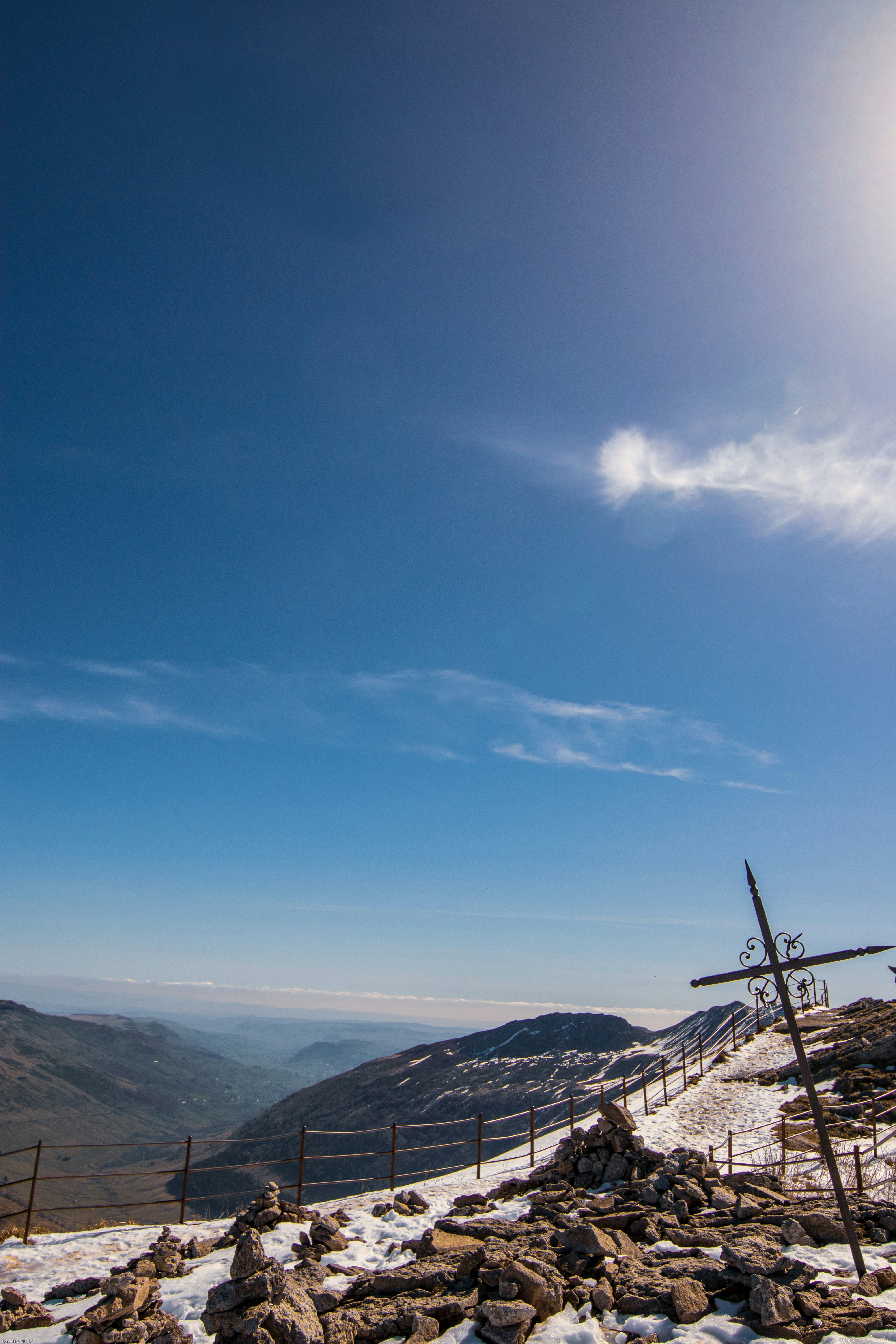 Cruza en una cima nevada bajo un cielo azul