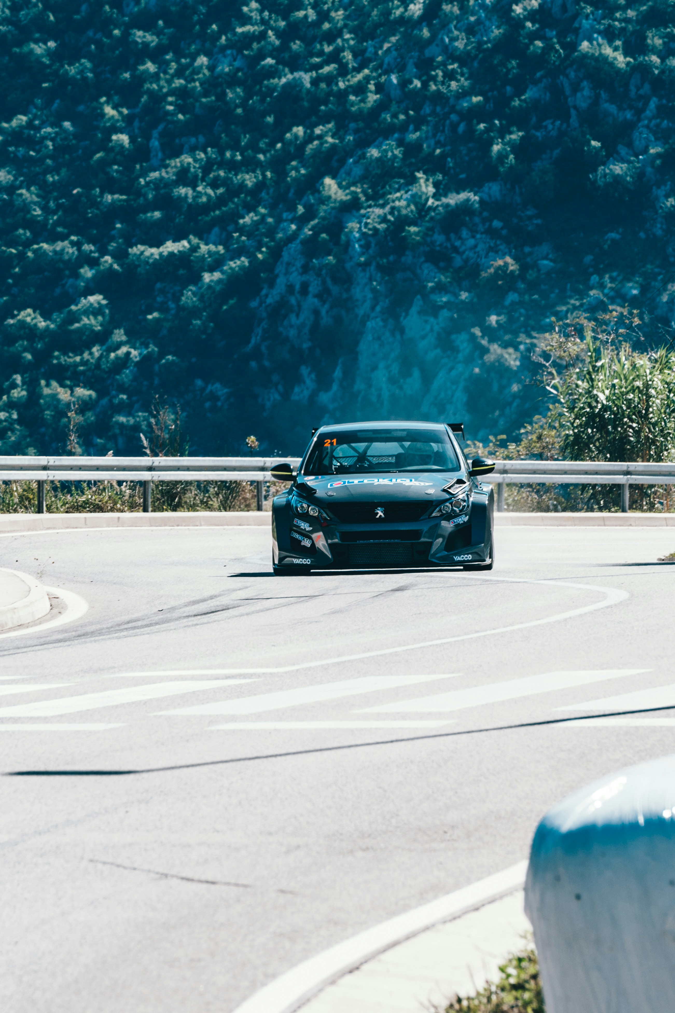 A dark sports car drives on a winding mountain road. photo – Free ...