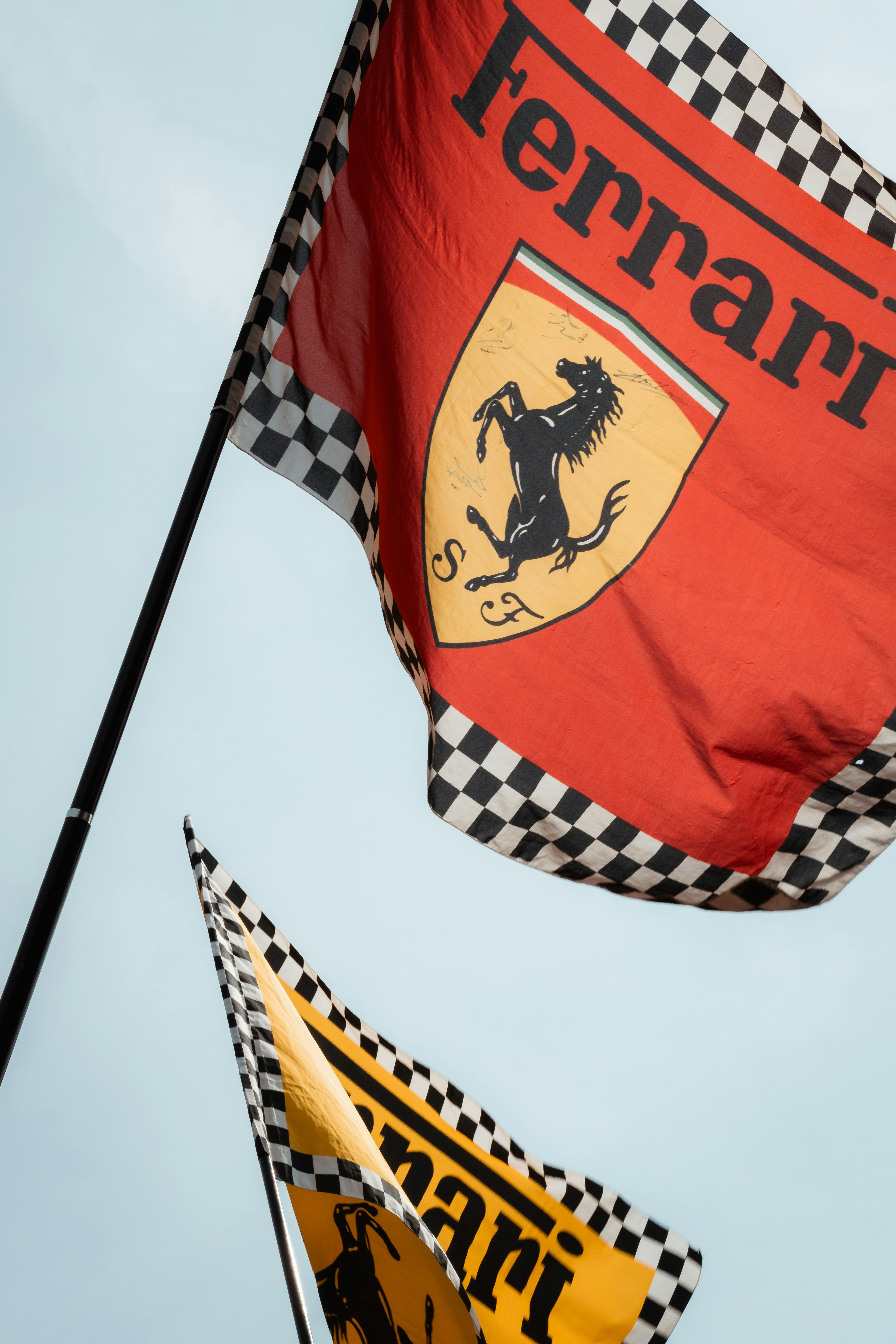 Dua bendera ferrari dengan batas kotak-kotak berkibar.