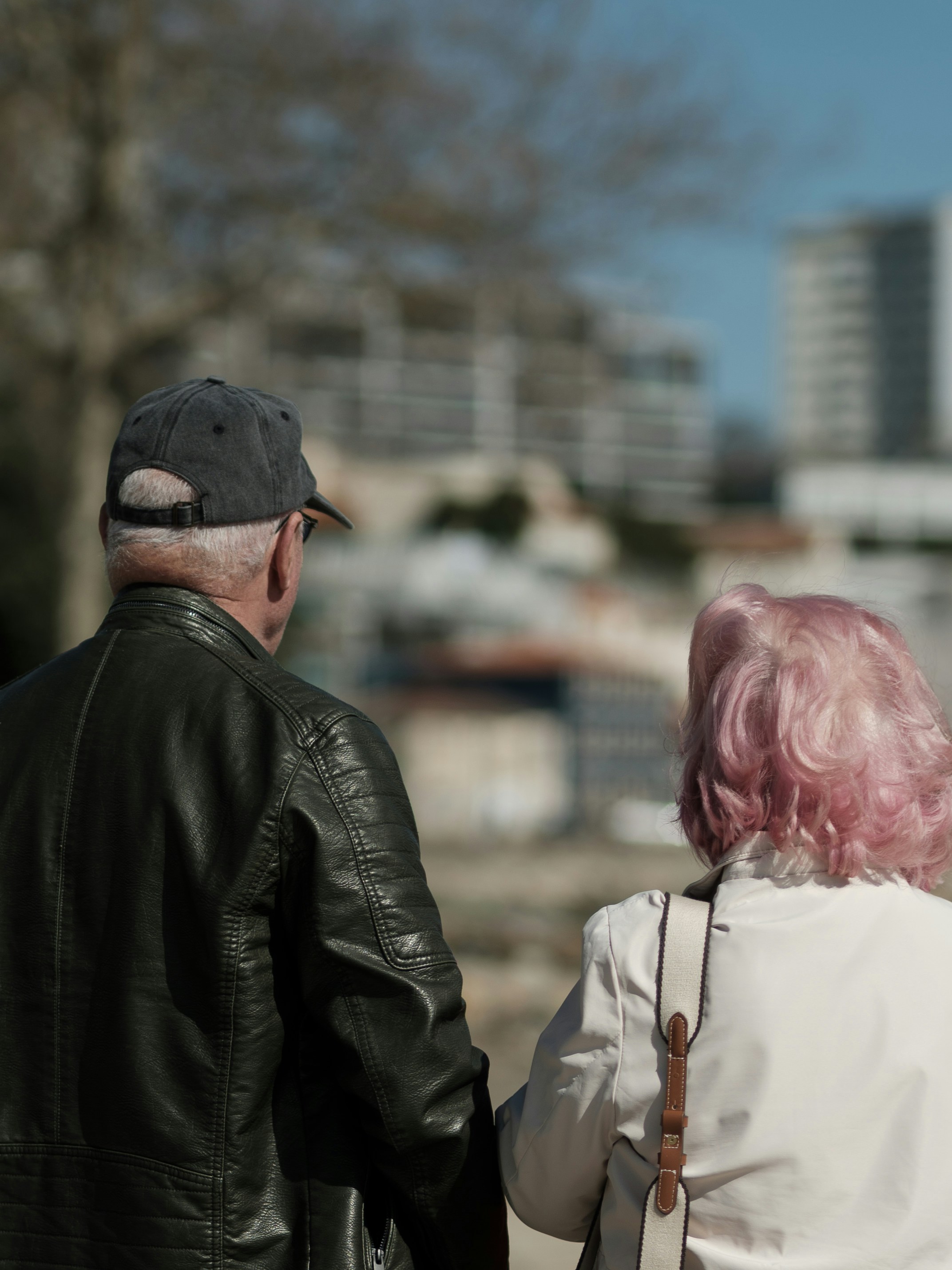 Elderly couple holding hands with pink hair.