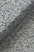 Close-up of a speckled terrazzo surface with a shadow