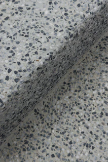 Close-up of a speckled terrazzo surface with a shadow