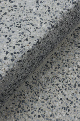 Close-up of a speckled terrazzo surface with a shadow