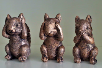Three bronze squirrel figurines covering their eyes, ears, and mouth.