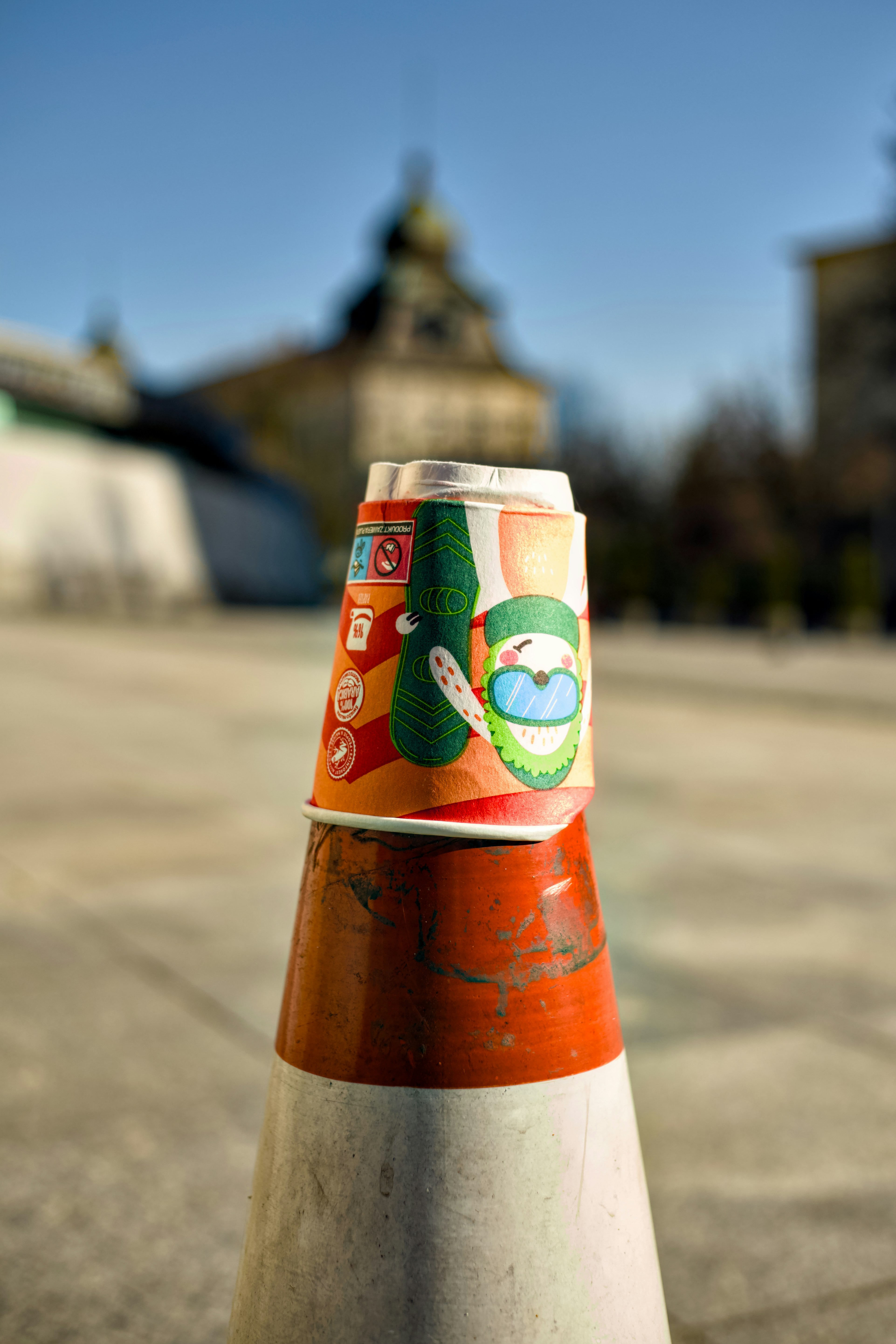 Zwei Einwegbecher, die auf einem Verkehrskegel gestapelt sind.