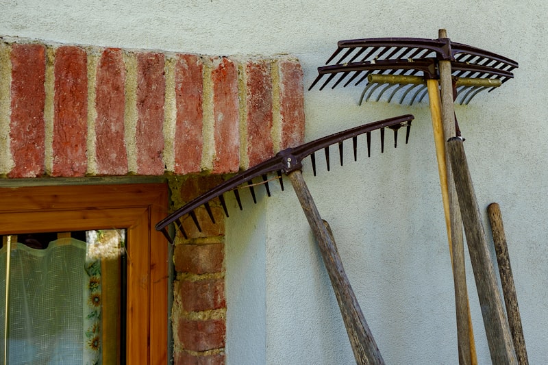 Rechen an einer Gartenwand