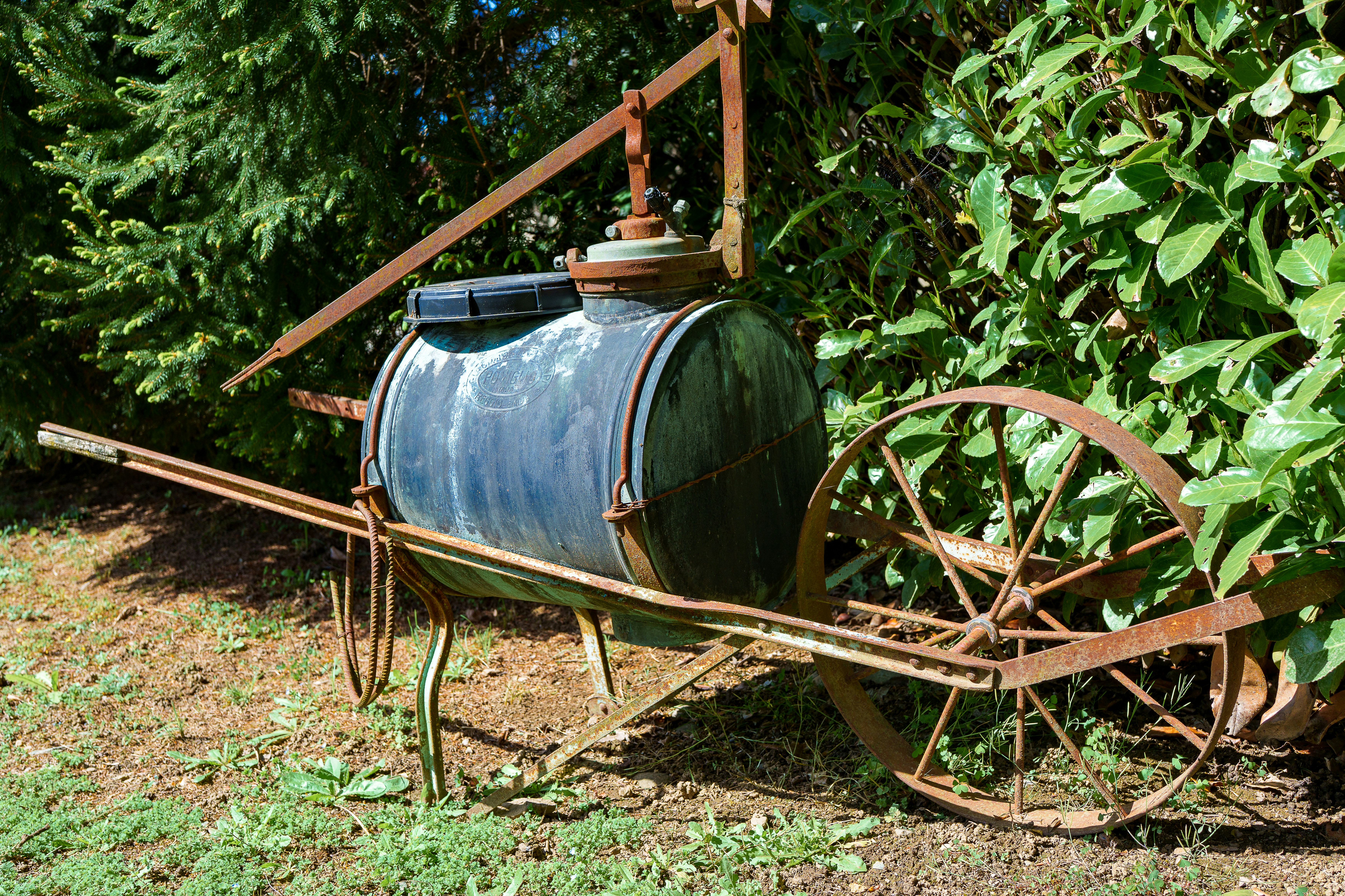 Rusty antique farm equipment with a water tank