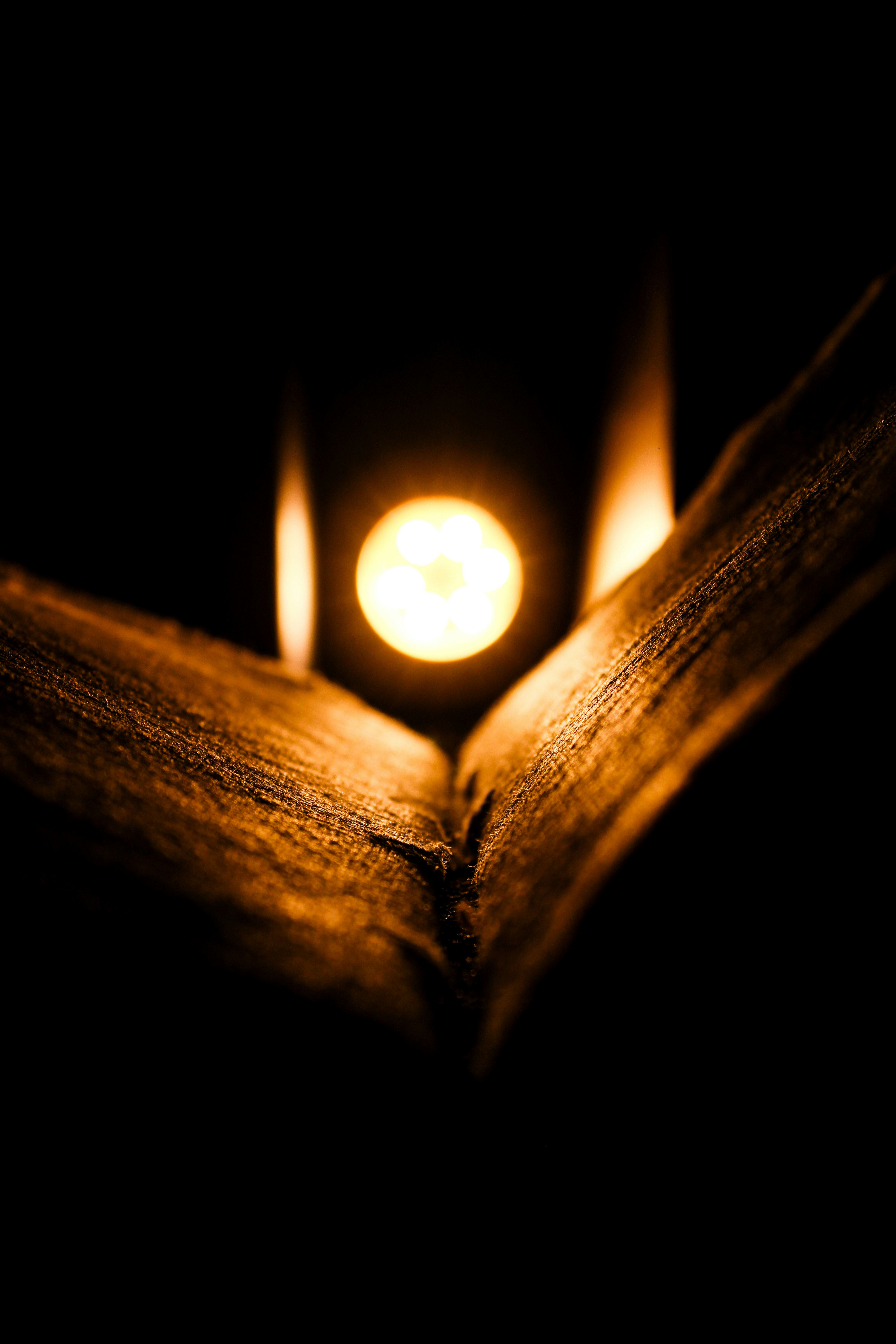 A close-up of a burning candle with a dark background