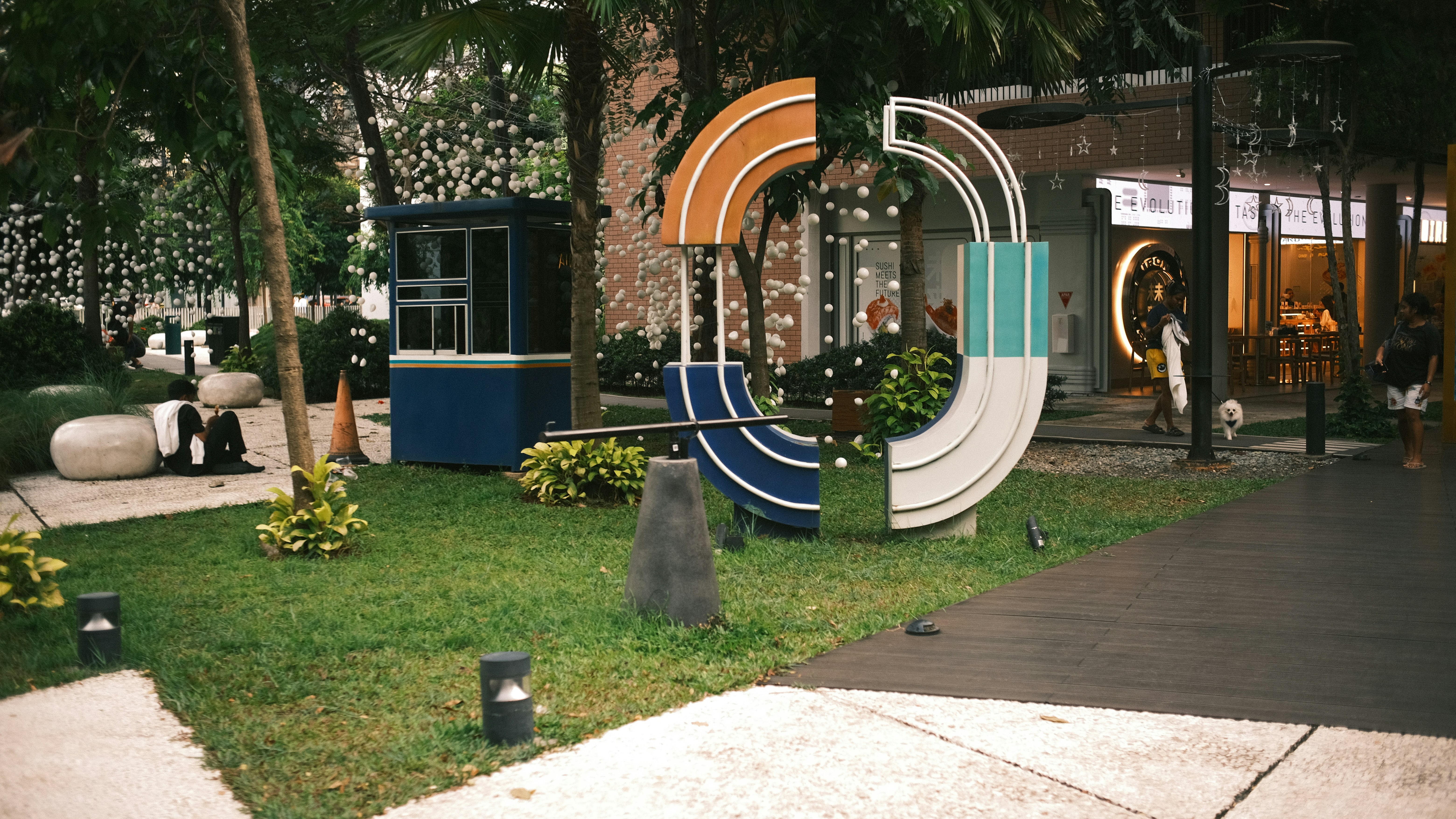 Patung seni modern di alun-alun perkotaan berumput