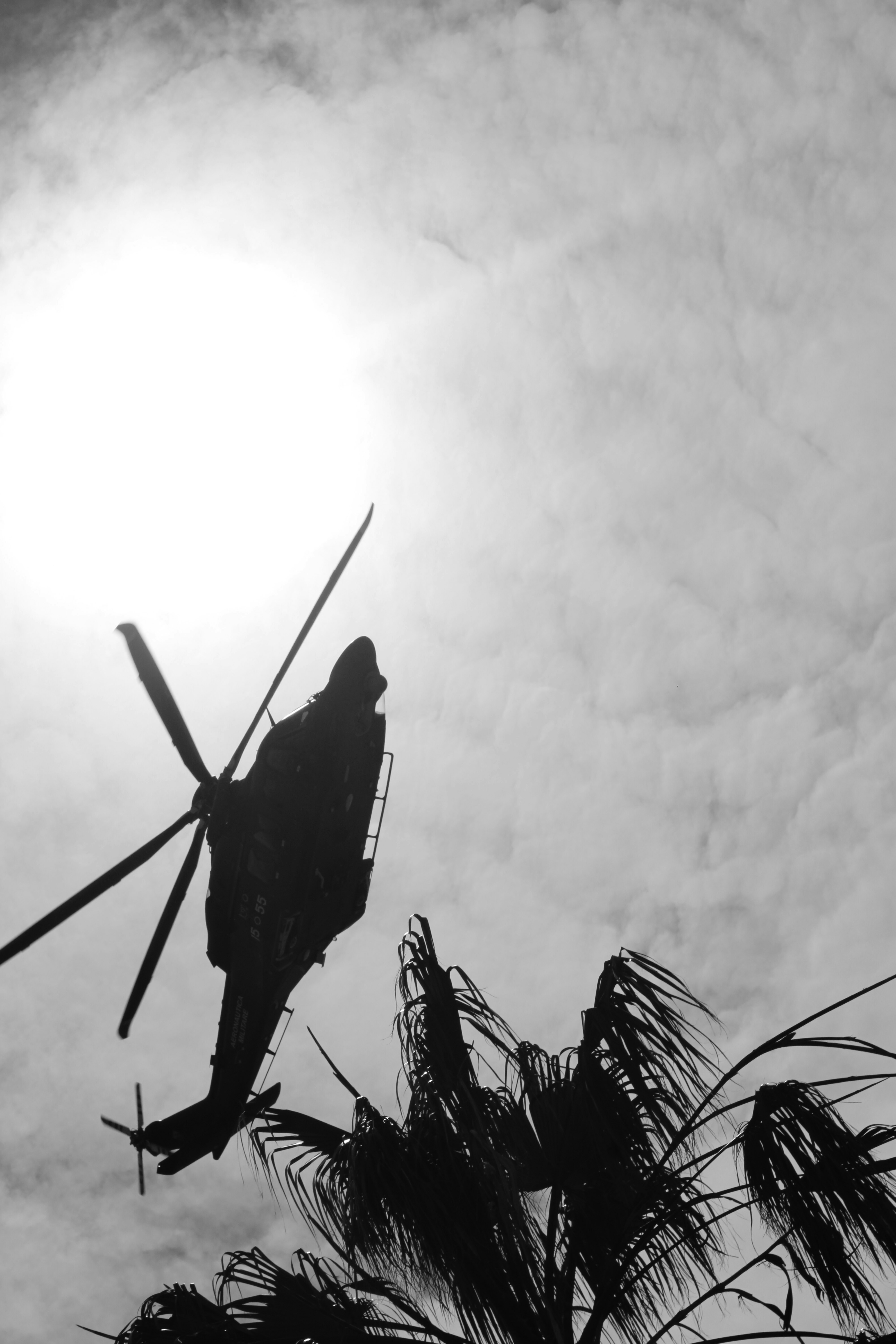 Silhouette eines Hubschraubers, der gegen die Sonne fliegt