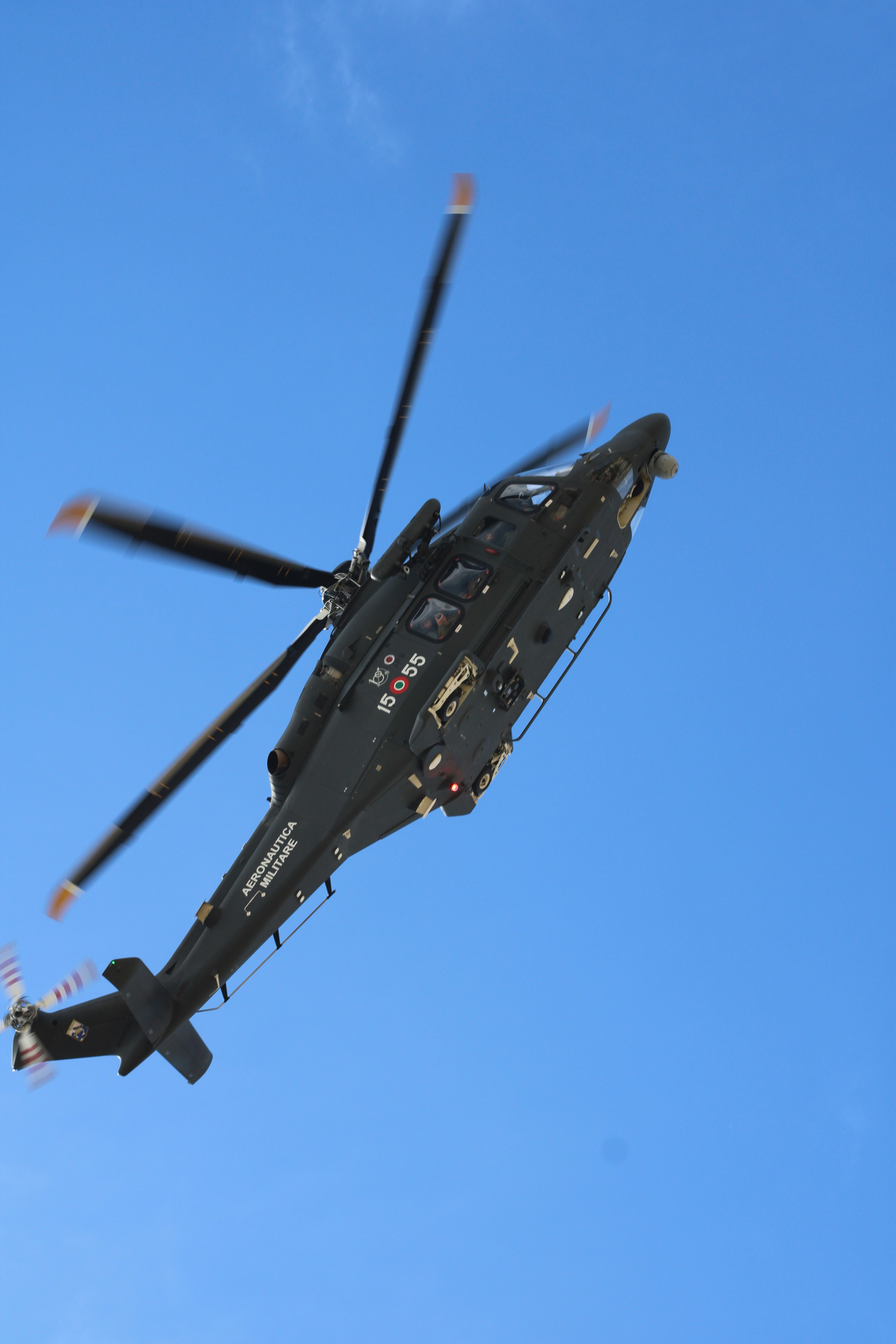 Ein schwarzer Hubschrauber, der an einem klaren blauen Himmel fliegt