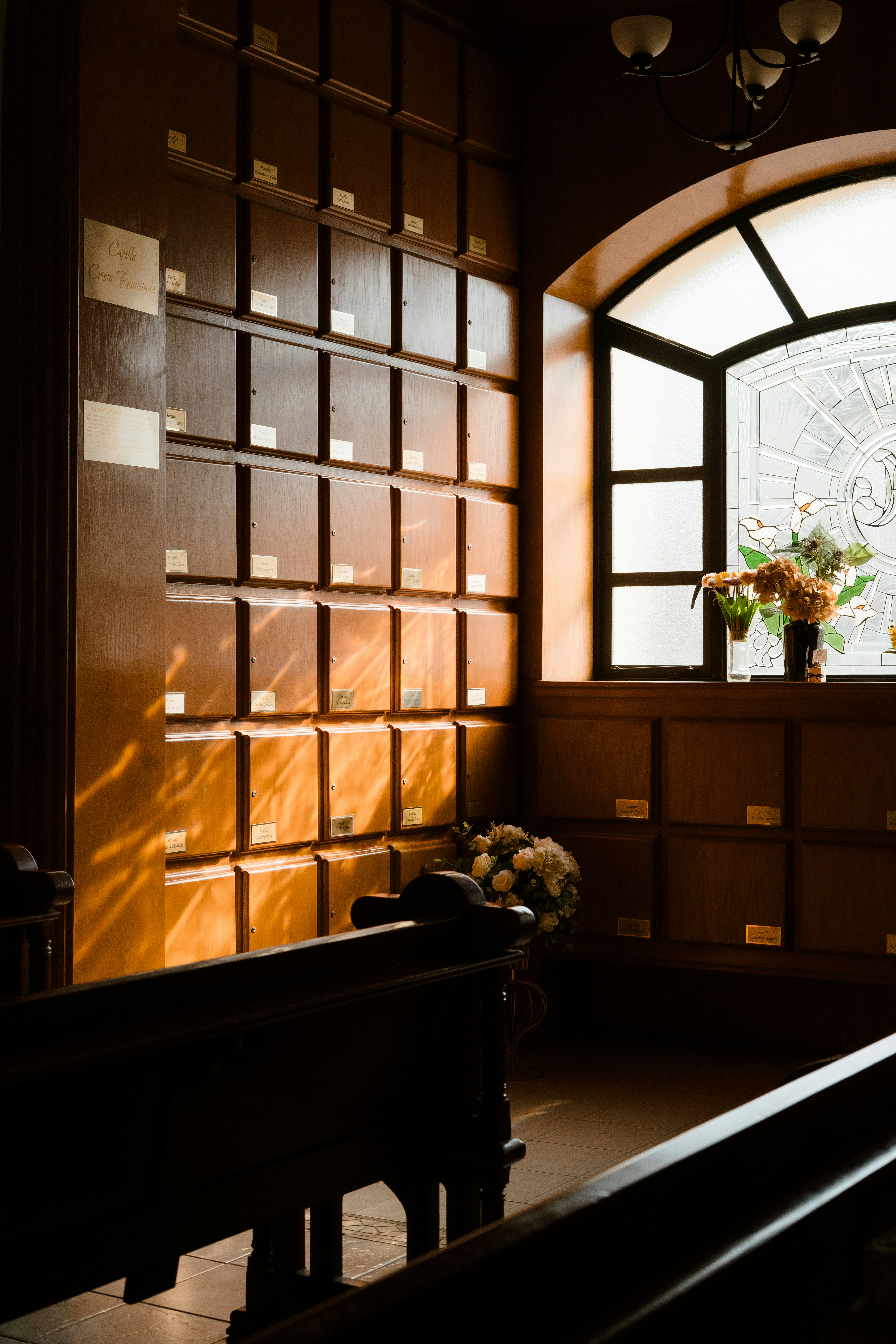 Reihen von Holznischen mit Blumen in der Nähe eines Fensters