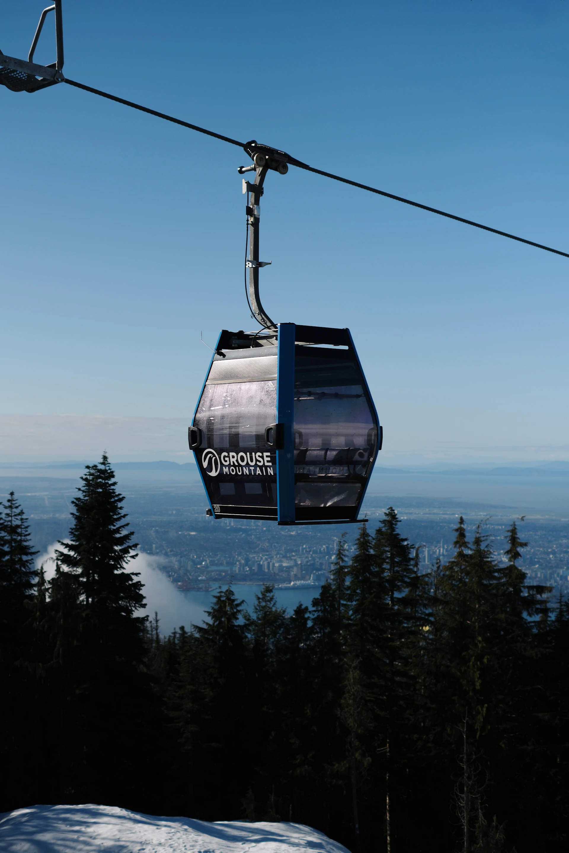Gondola traveling up a mountain with city below