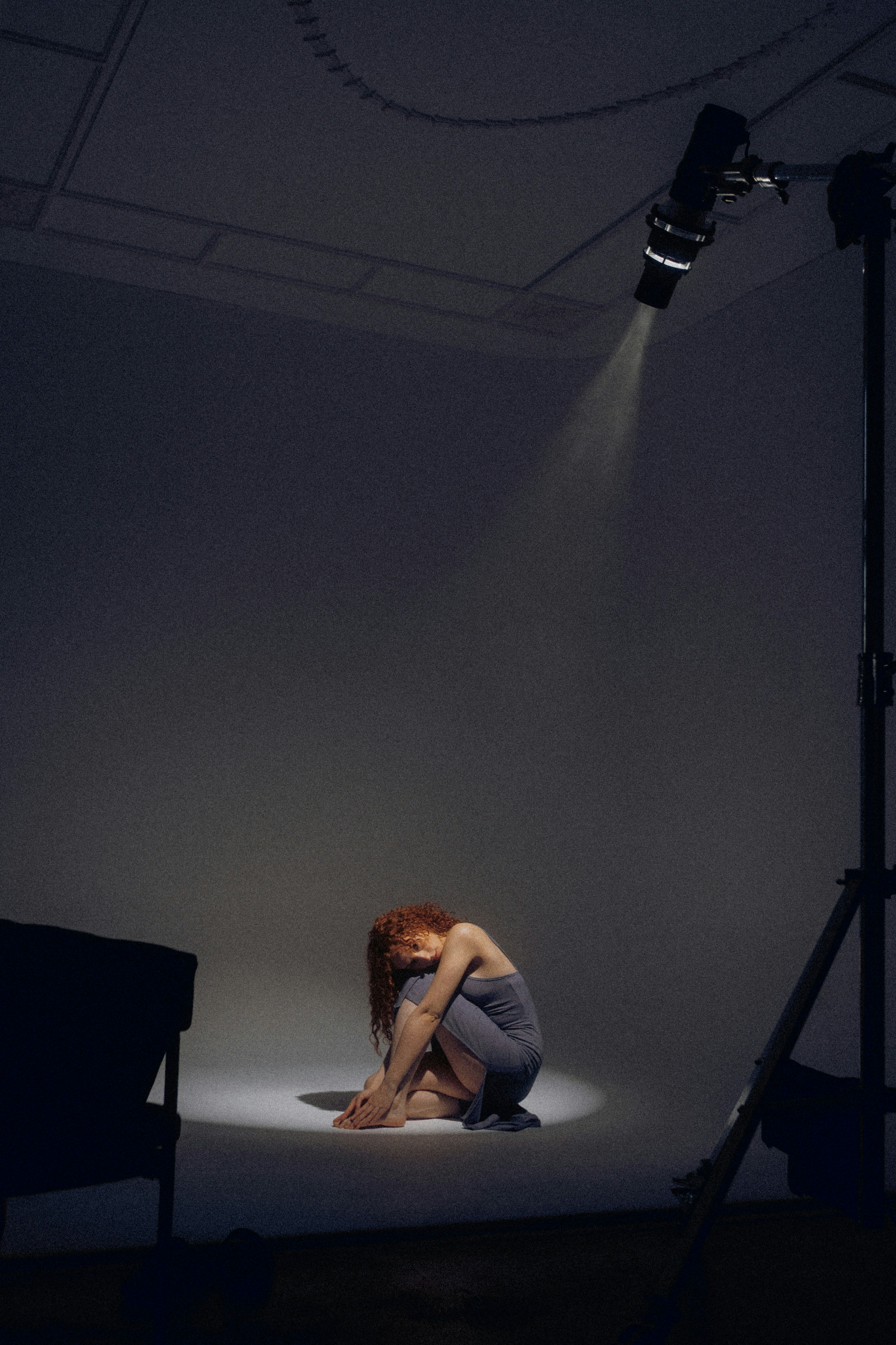 Femme sous les projecteurs sur une scène sombre