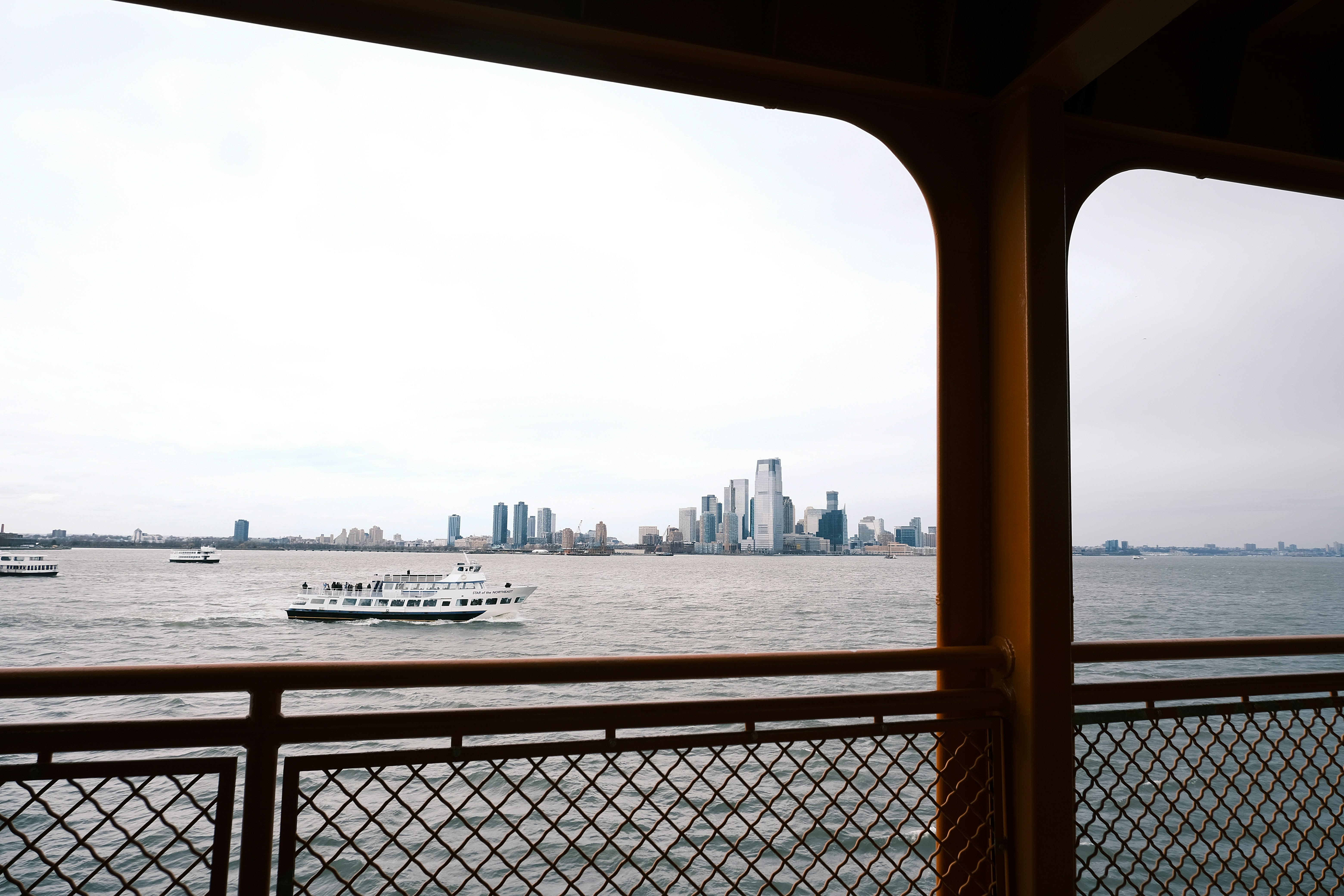 City skyline across the water with a ferry boat.