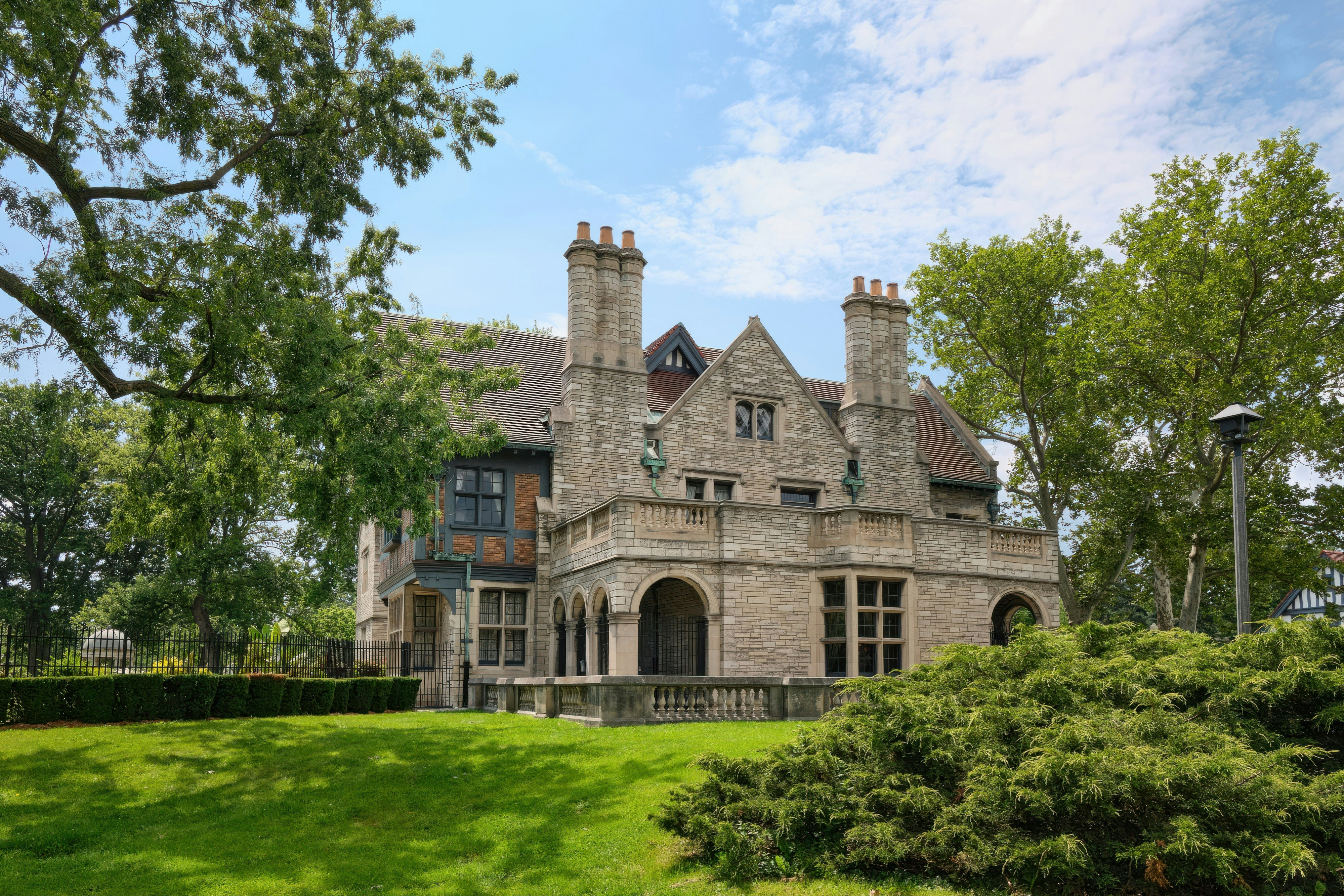 A grand stone mansion with arched windows and chimneys.