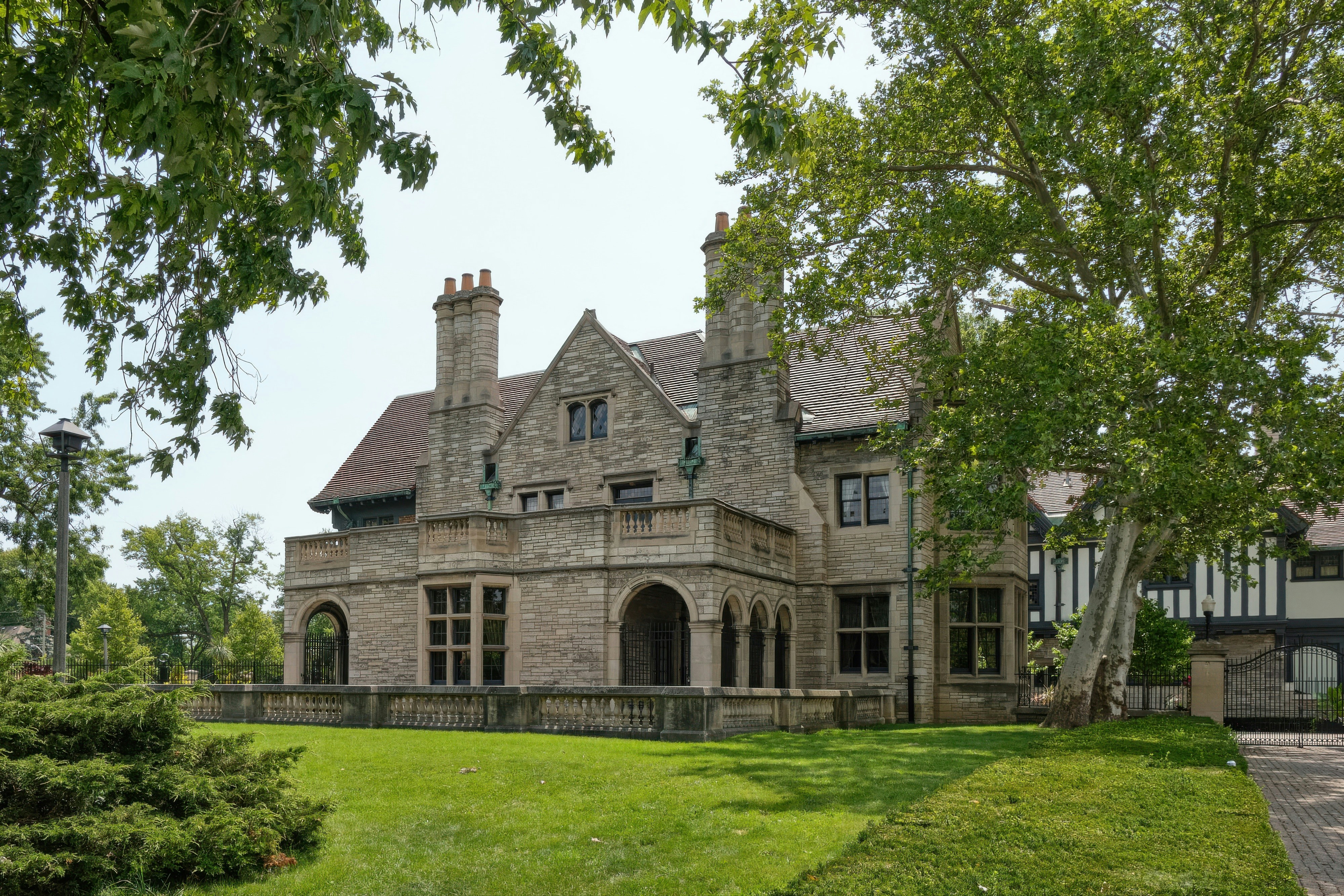 A large stone mansion with a manicured lawn.