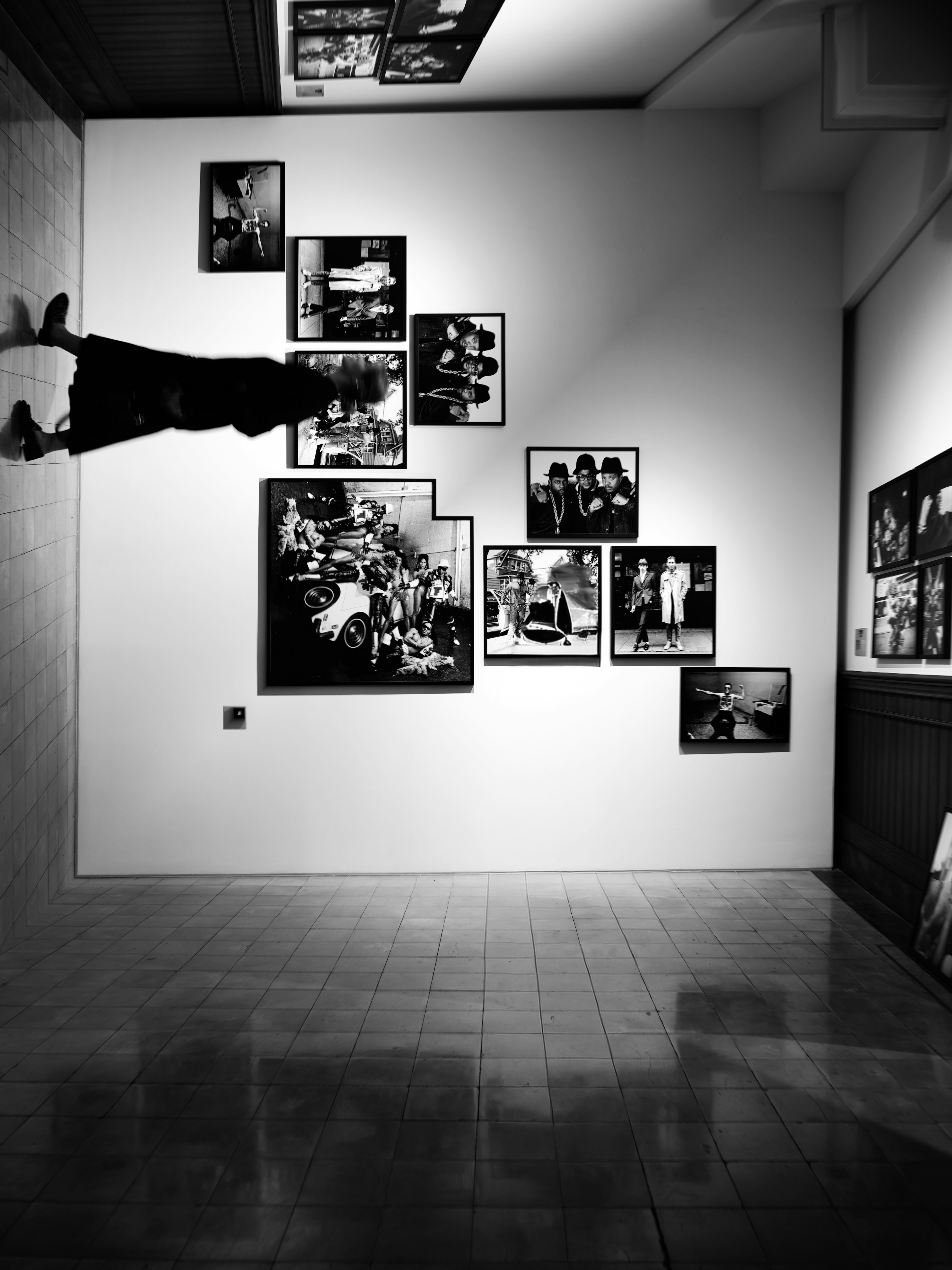 Fotos em preto e branco exibidas em uma parede de galeria.