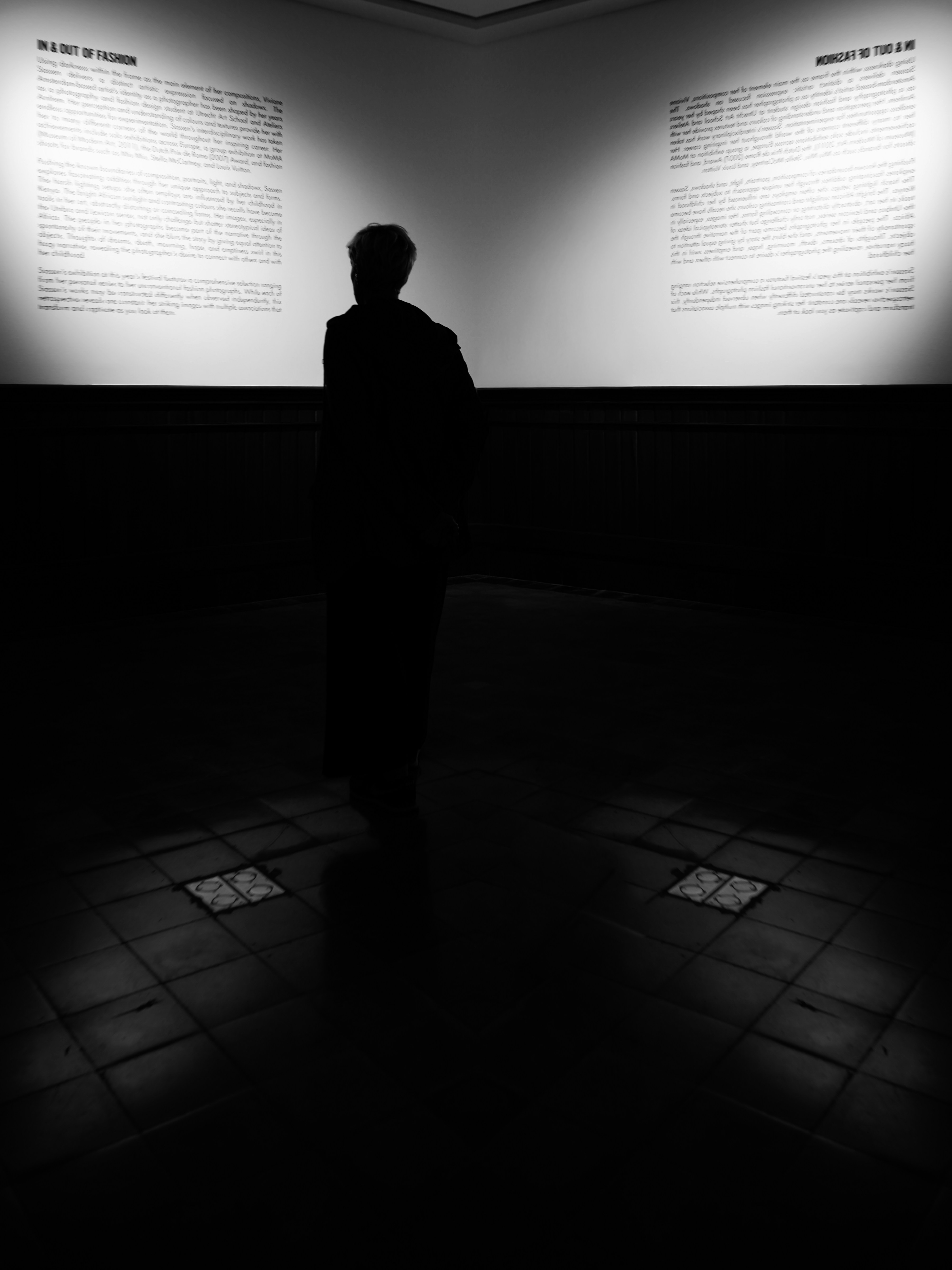 Silhouette of a person viewing text on a wall