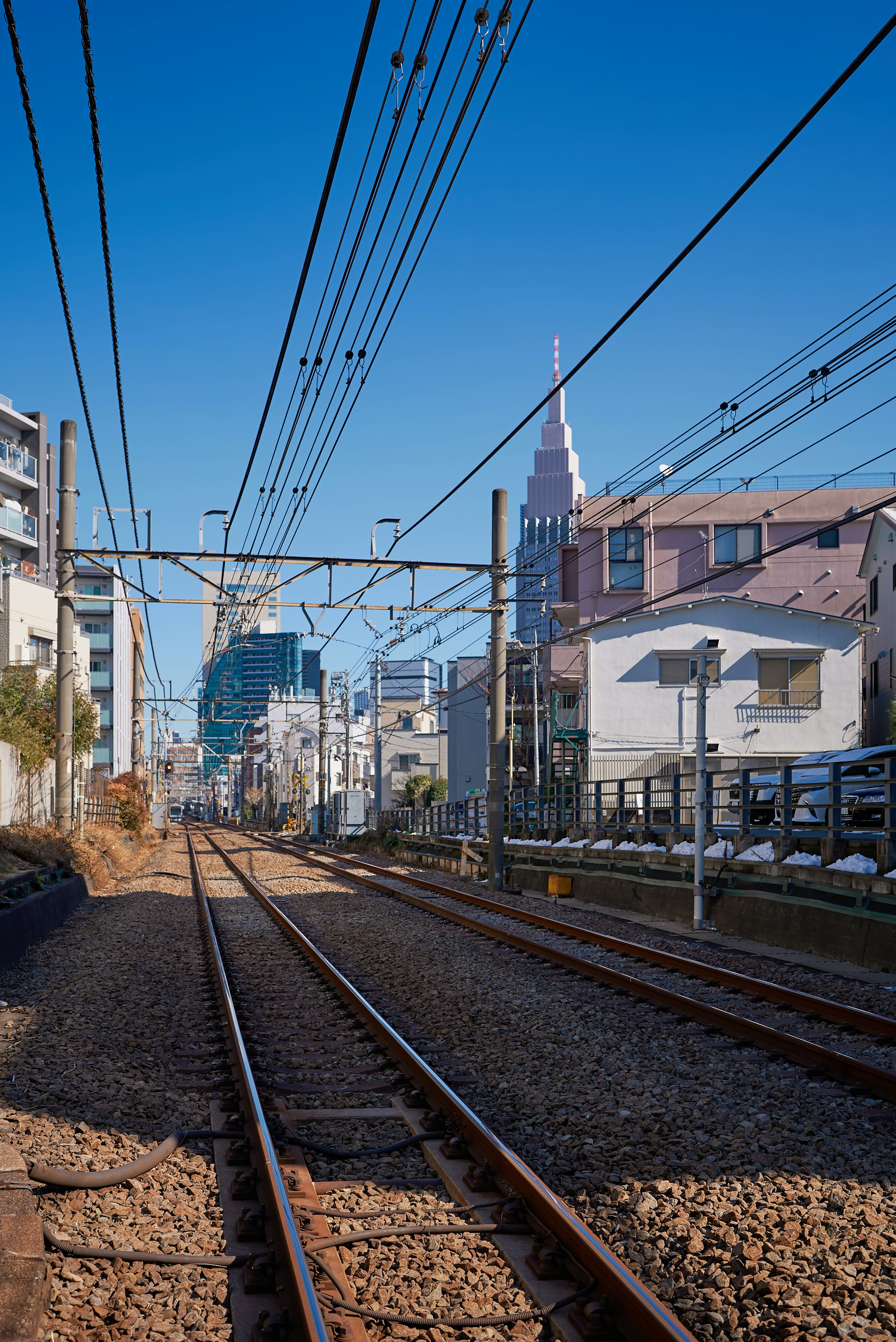 Train tracks leading towards a city skyline