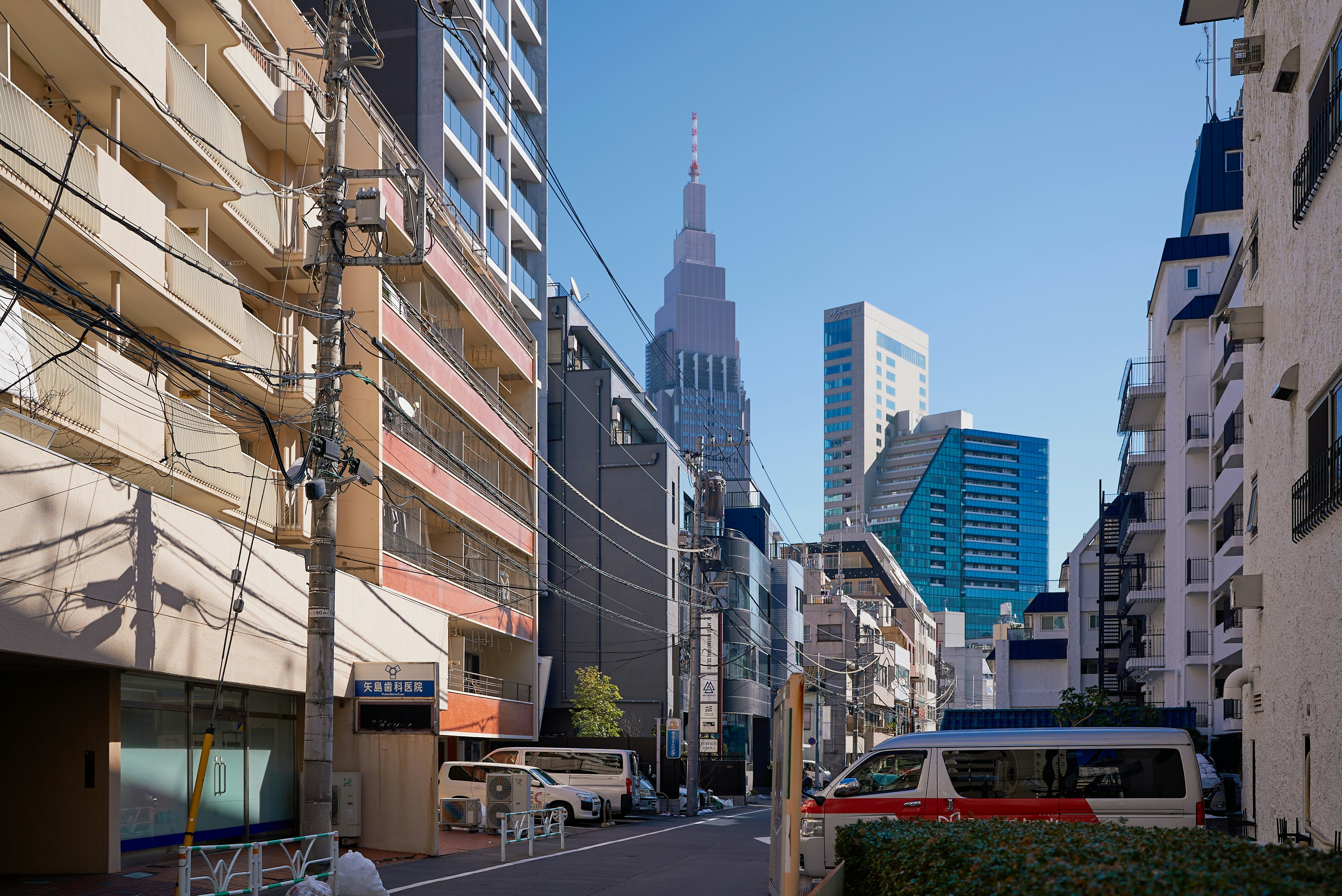 Tall skyscraper in a city street with buildings.