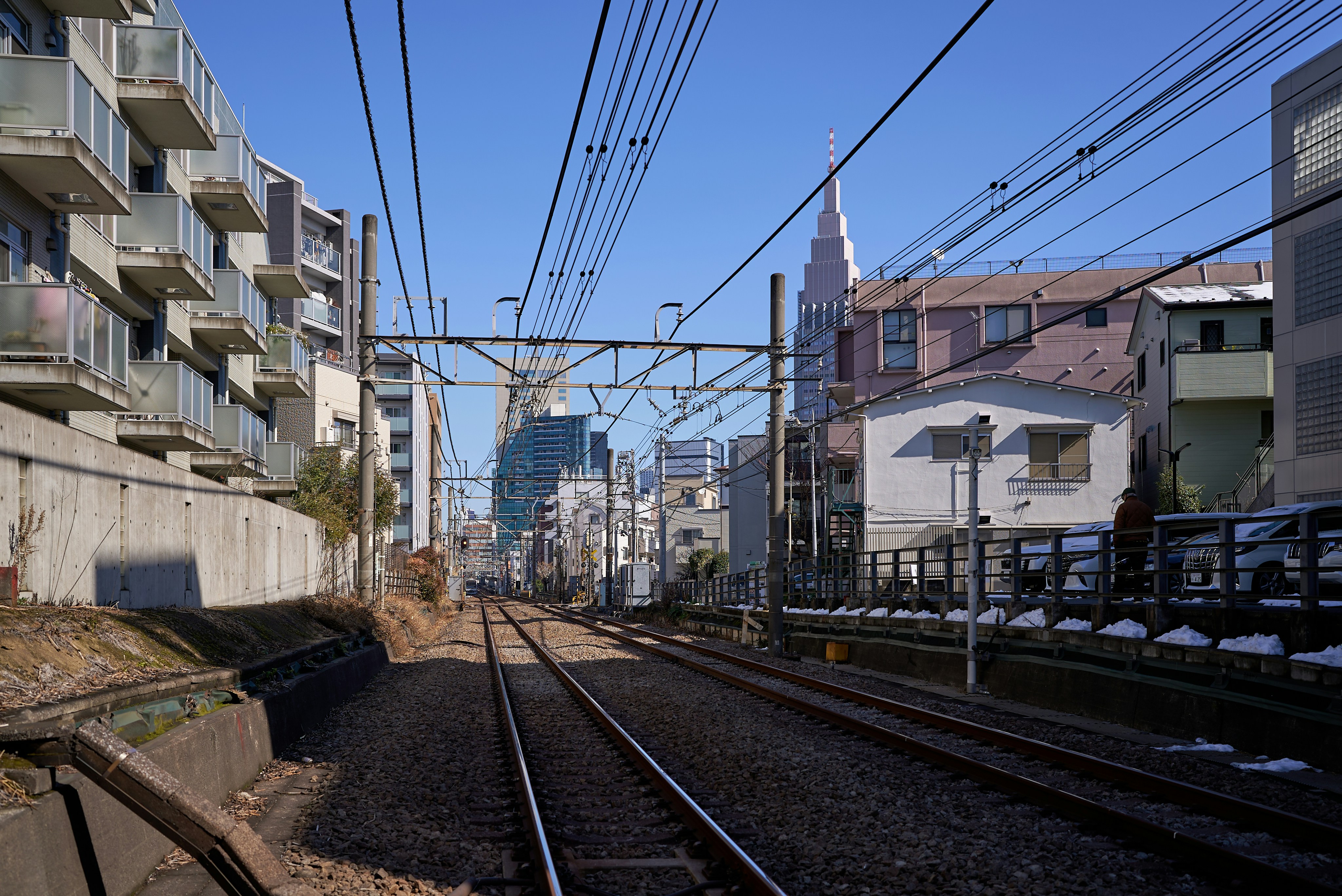 Train tracks leading into a city with buildings.