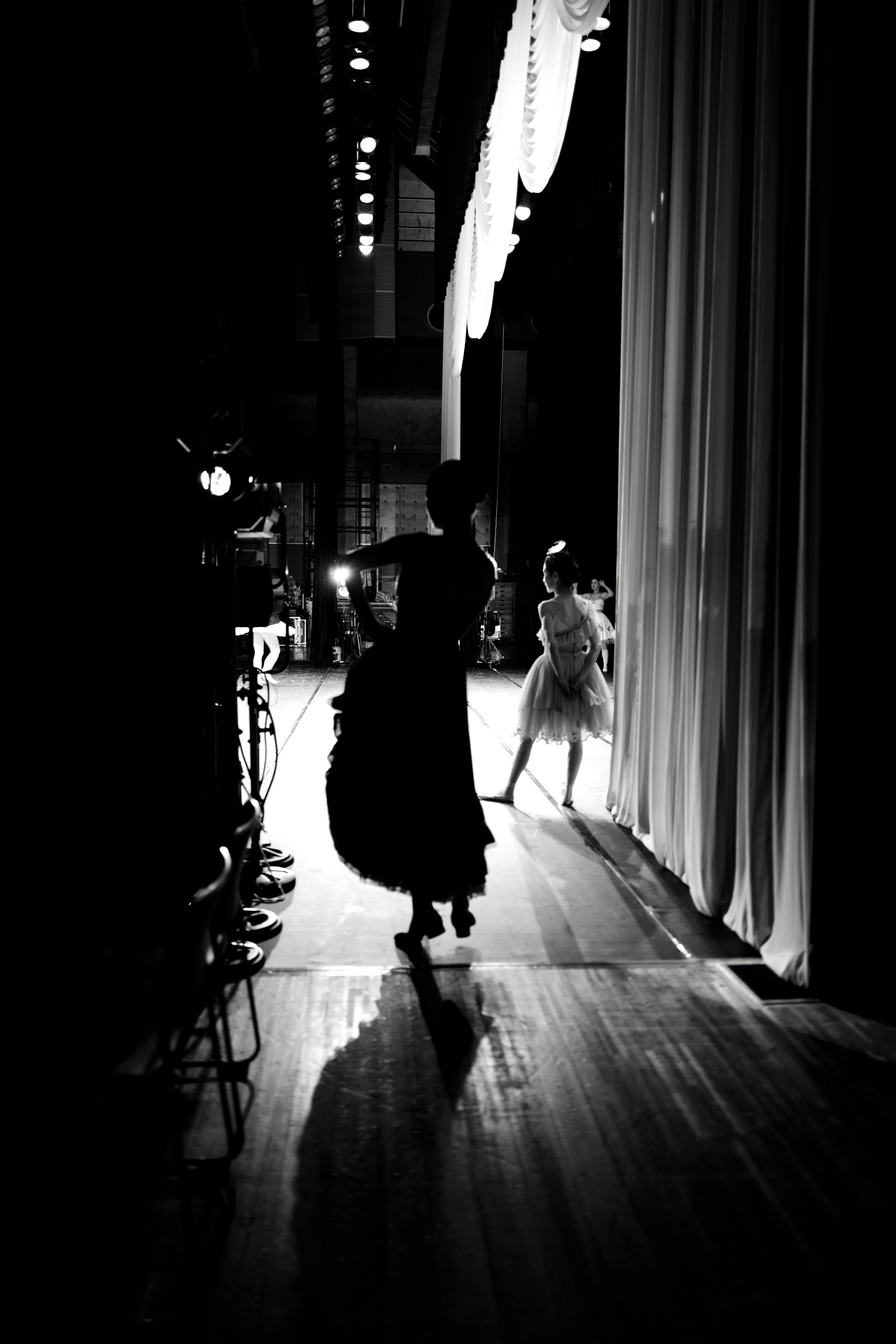 Des danseurs s’entraînant sur une scène faiblement éclairée