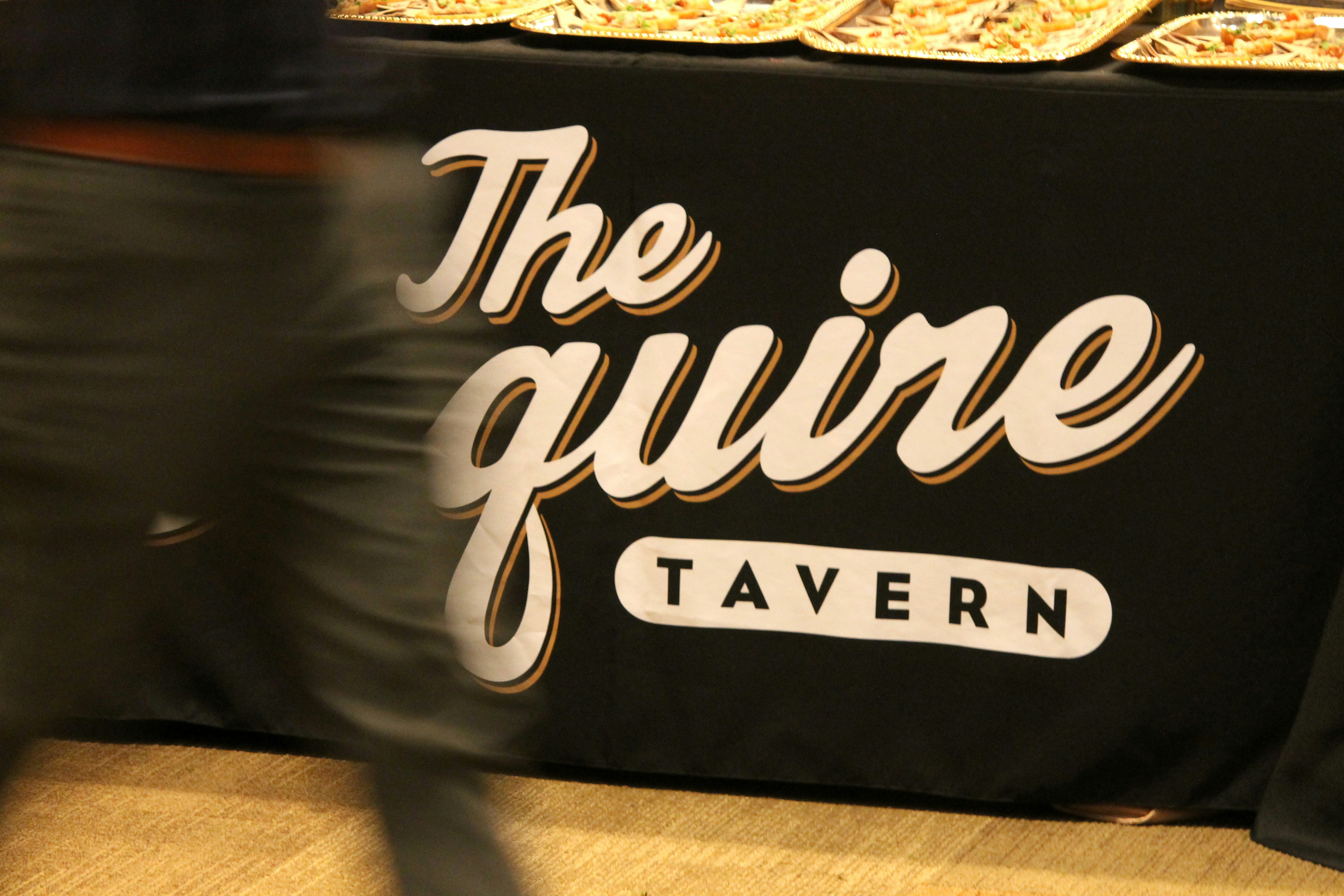 Le logo de la taverne du squire sur une nappe noire