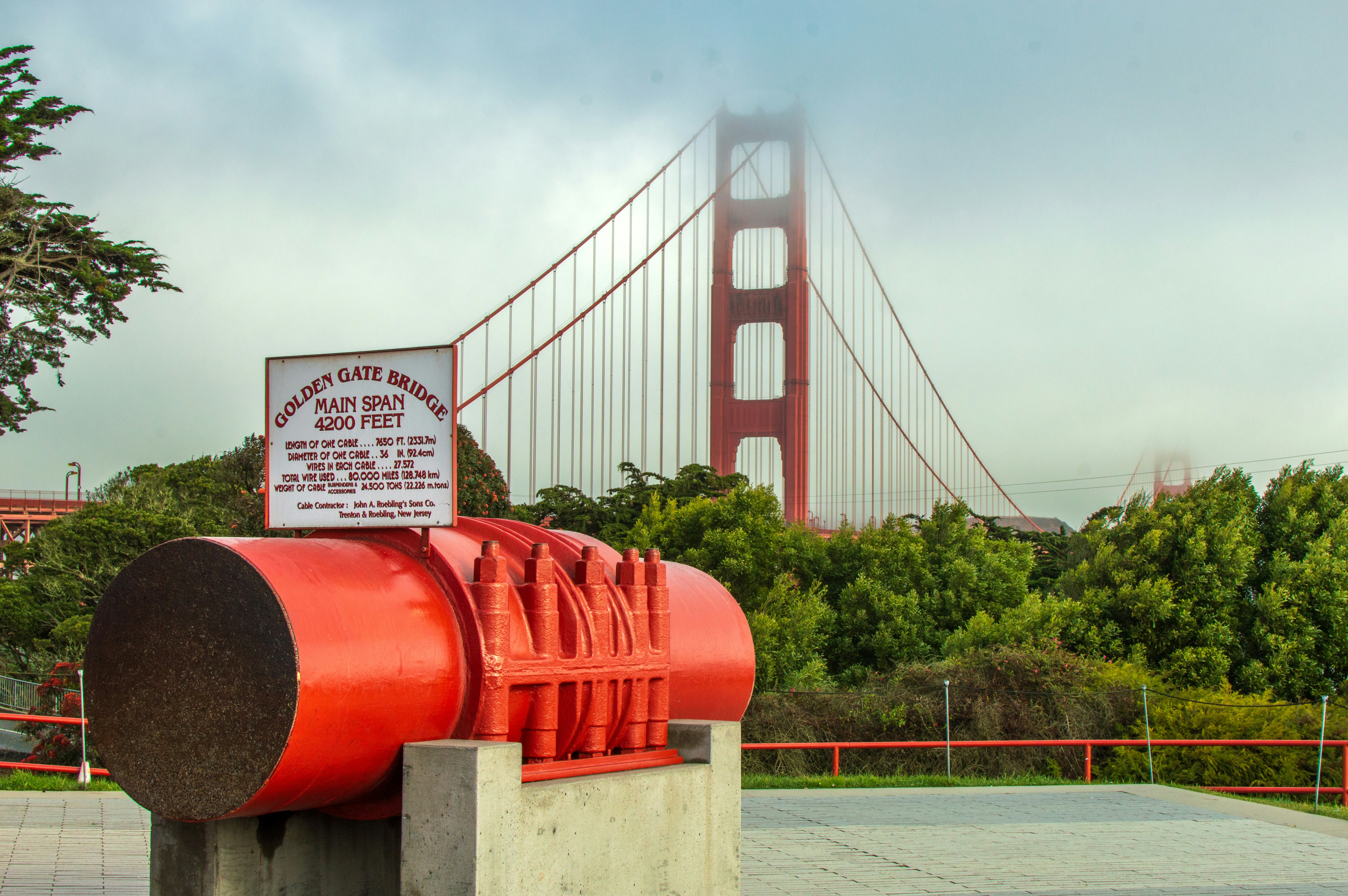 Golden gate bridge with a large red anchor chain segment.