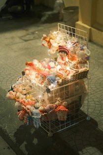 Stuffed toys displayed on a wire rack with lights