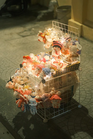 Stuffed toys displayed on a wire rack with lights