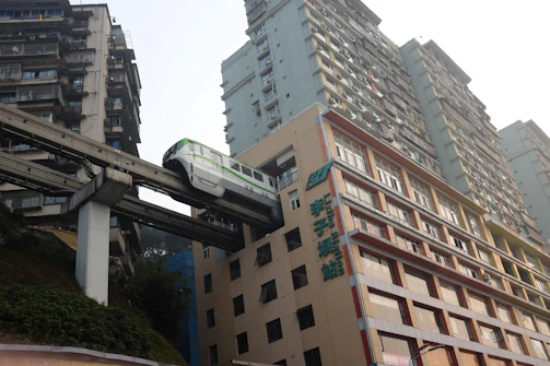 Monorail train passes through a building in a city.