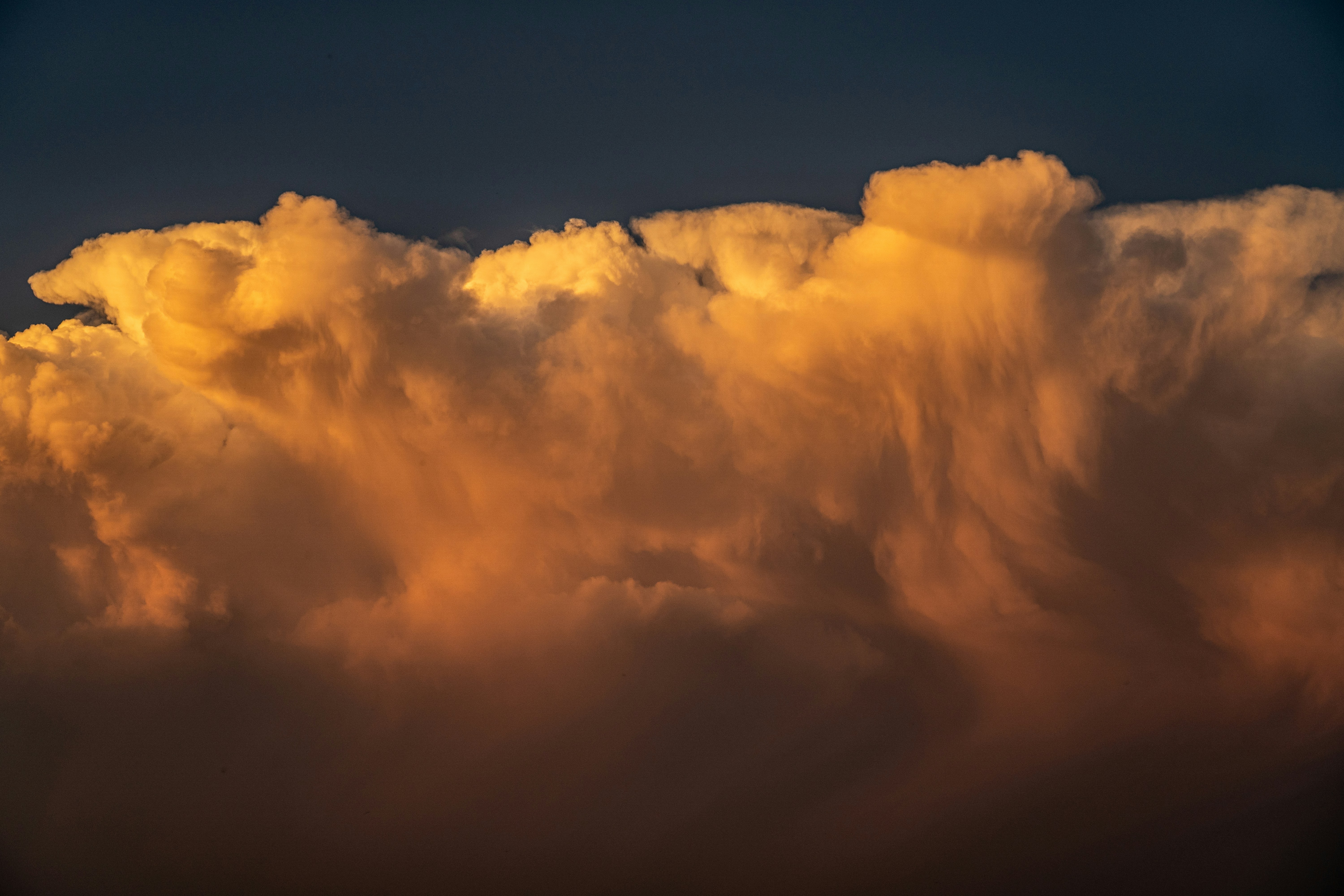 Nubes doradas iluminadas por el atardecer contra el cielo oscuro