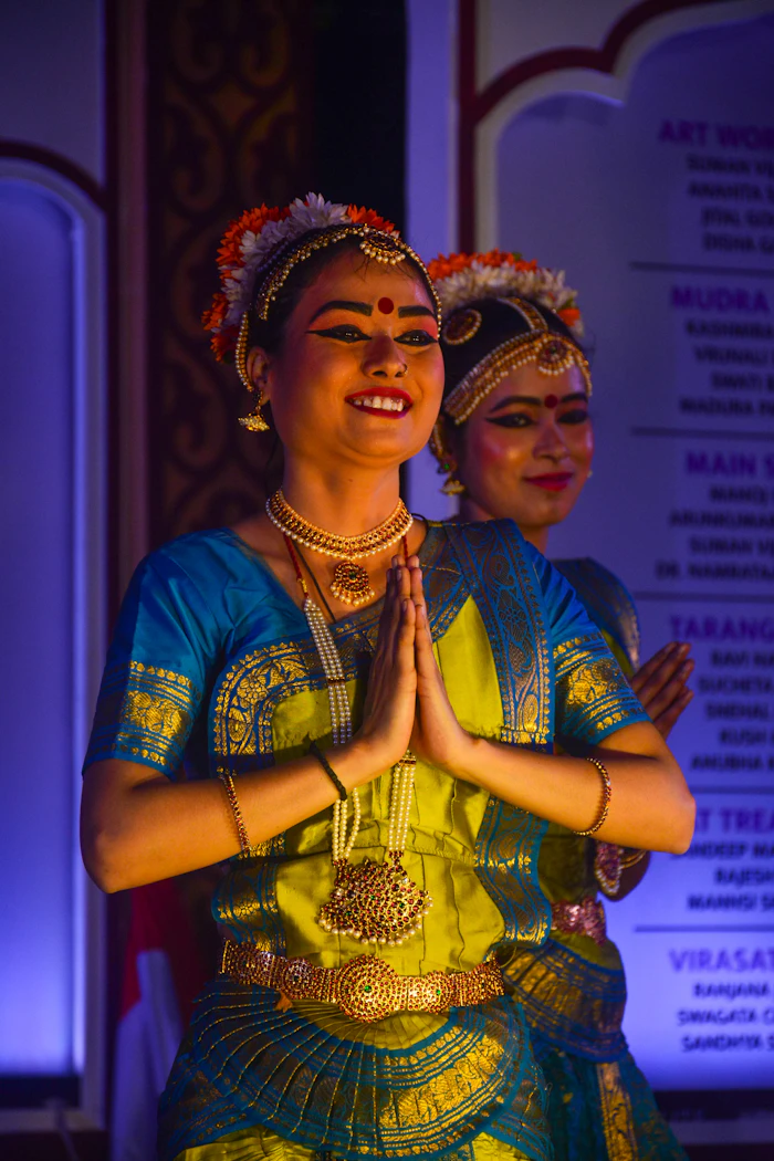 Two dancers in traditional costume with hands joined in namaskaram