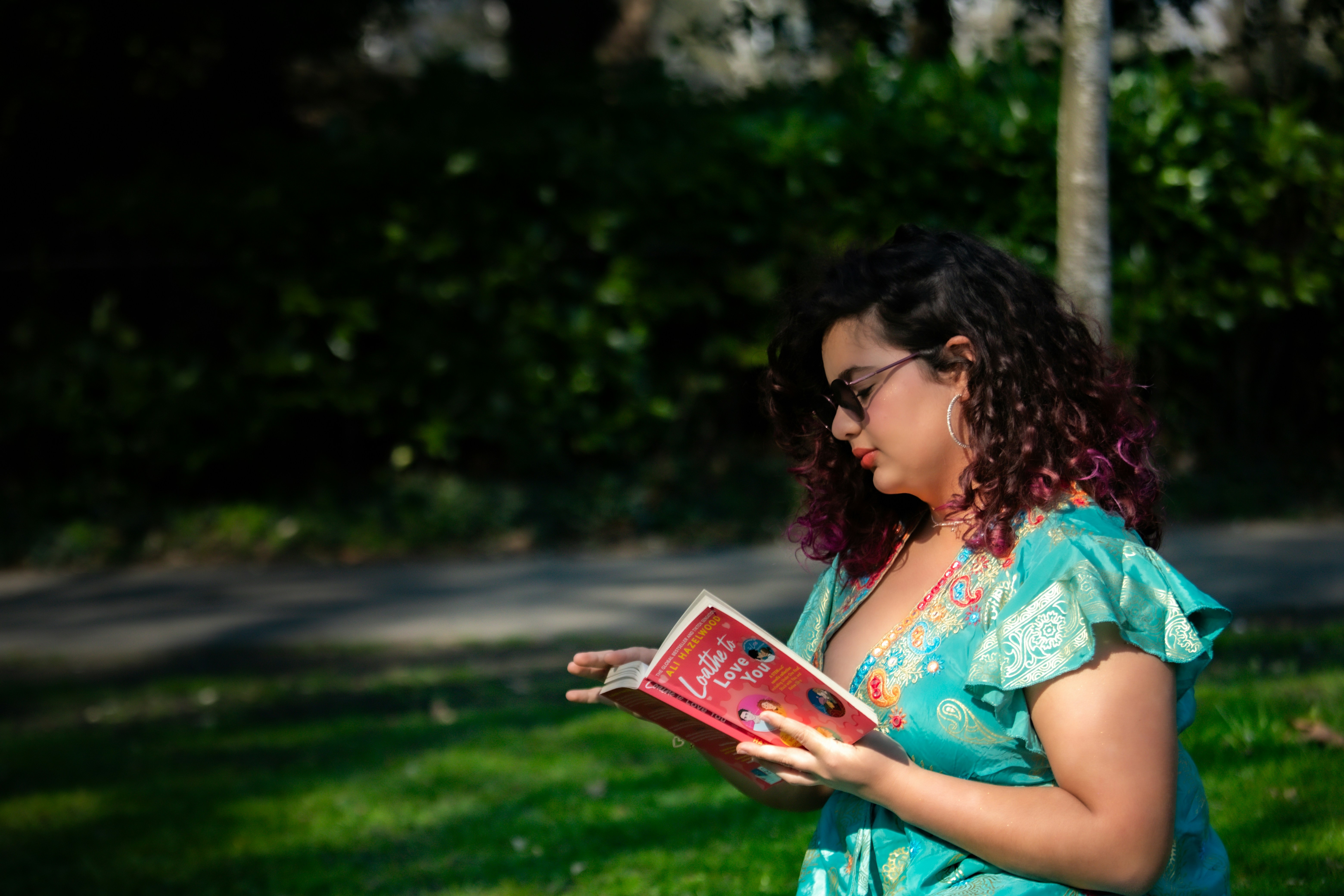 Una donna che legge un libro in un parco.