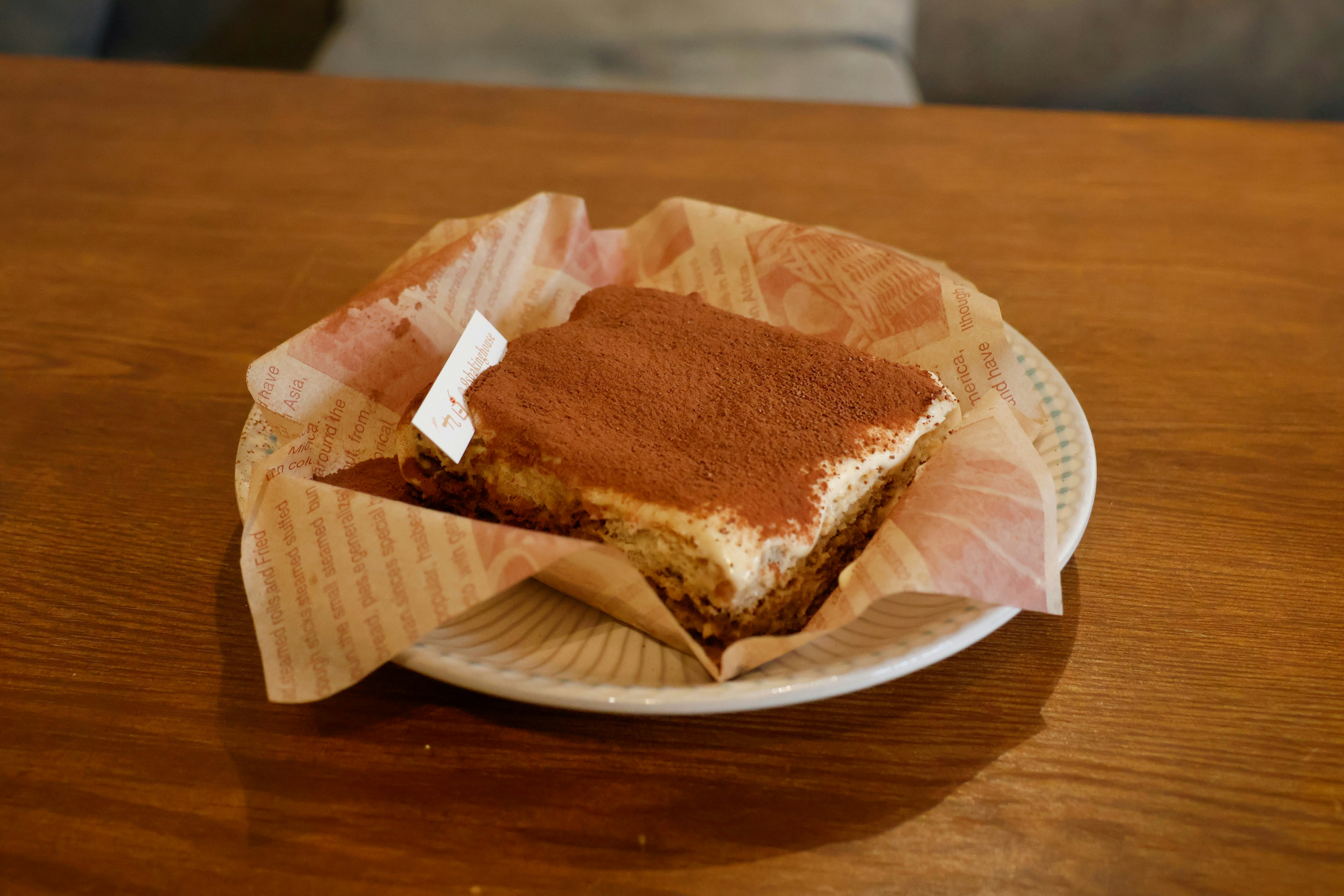 A slice of tiramisu dusted with cocoa powder