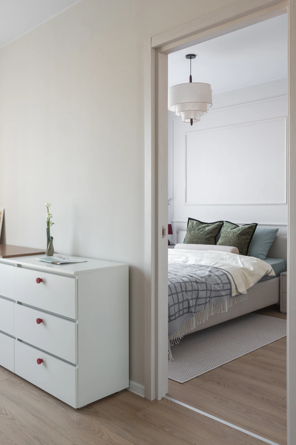 White bedroom dresser beside a coordinated bed