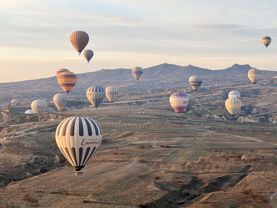 Cappadocia - Hot air balloons rising over Cappadocia's rocky valleys at sunrise