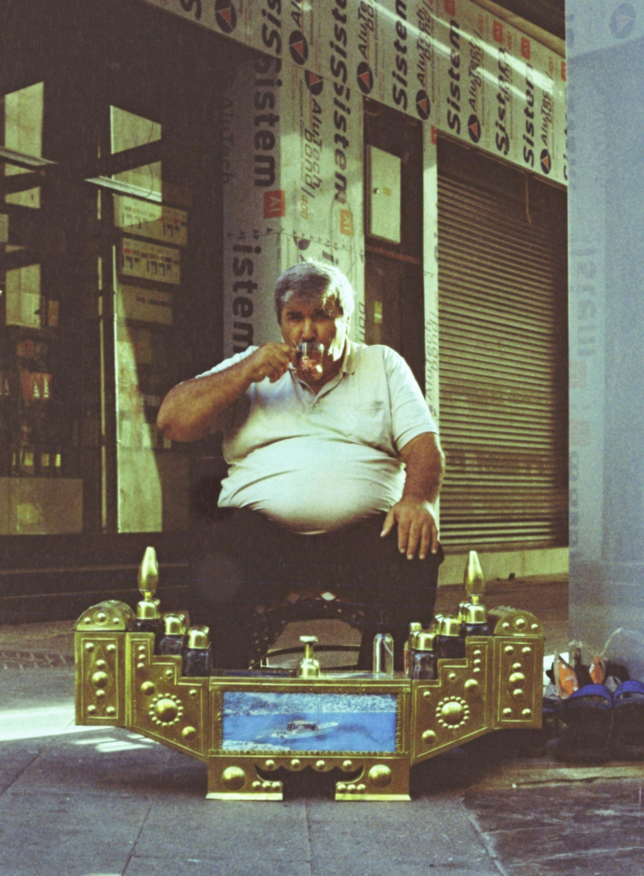 Man sitting on a shoe shine chair with drink