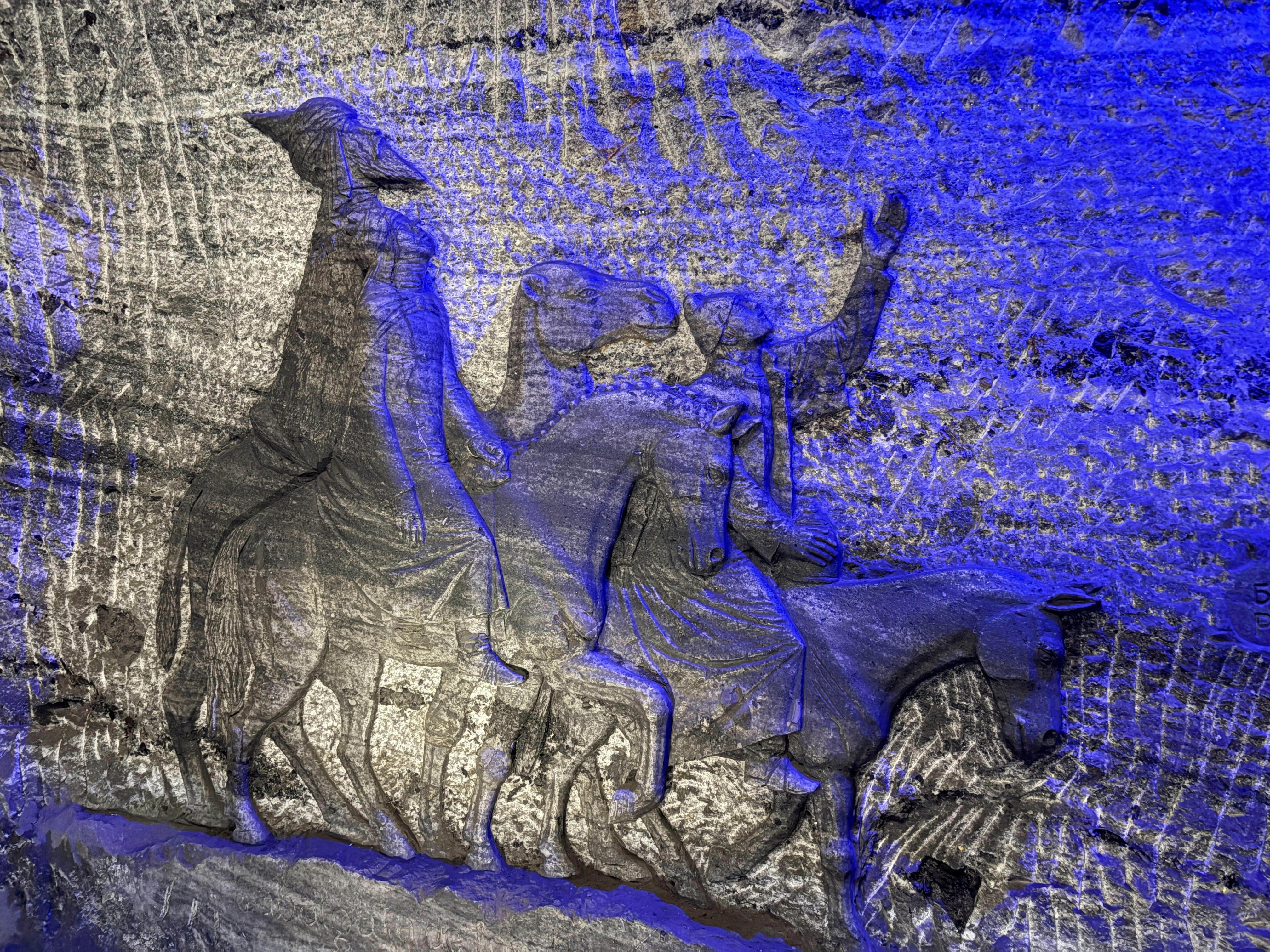 Three figures carved into a salt wall on horseback
