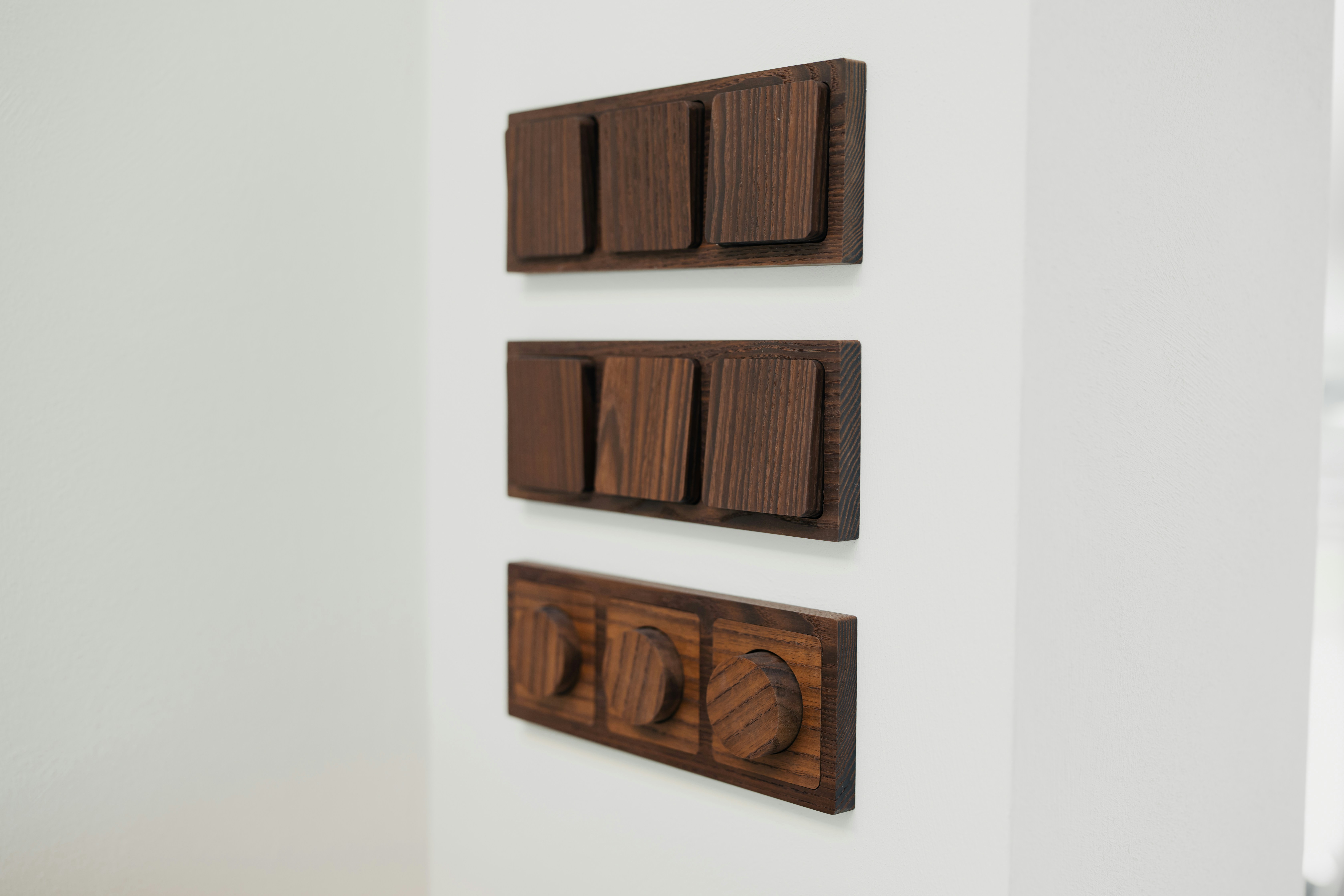 Close-up of thermowood wall switches highlighting natural texture and precise craftsmanship.