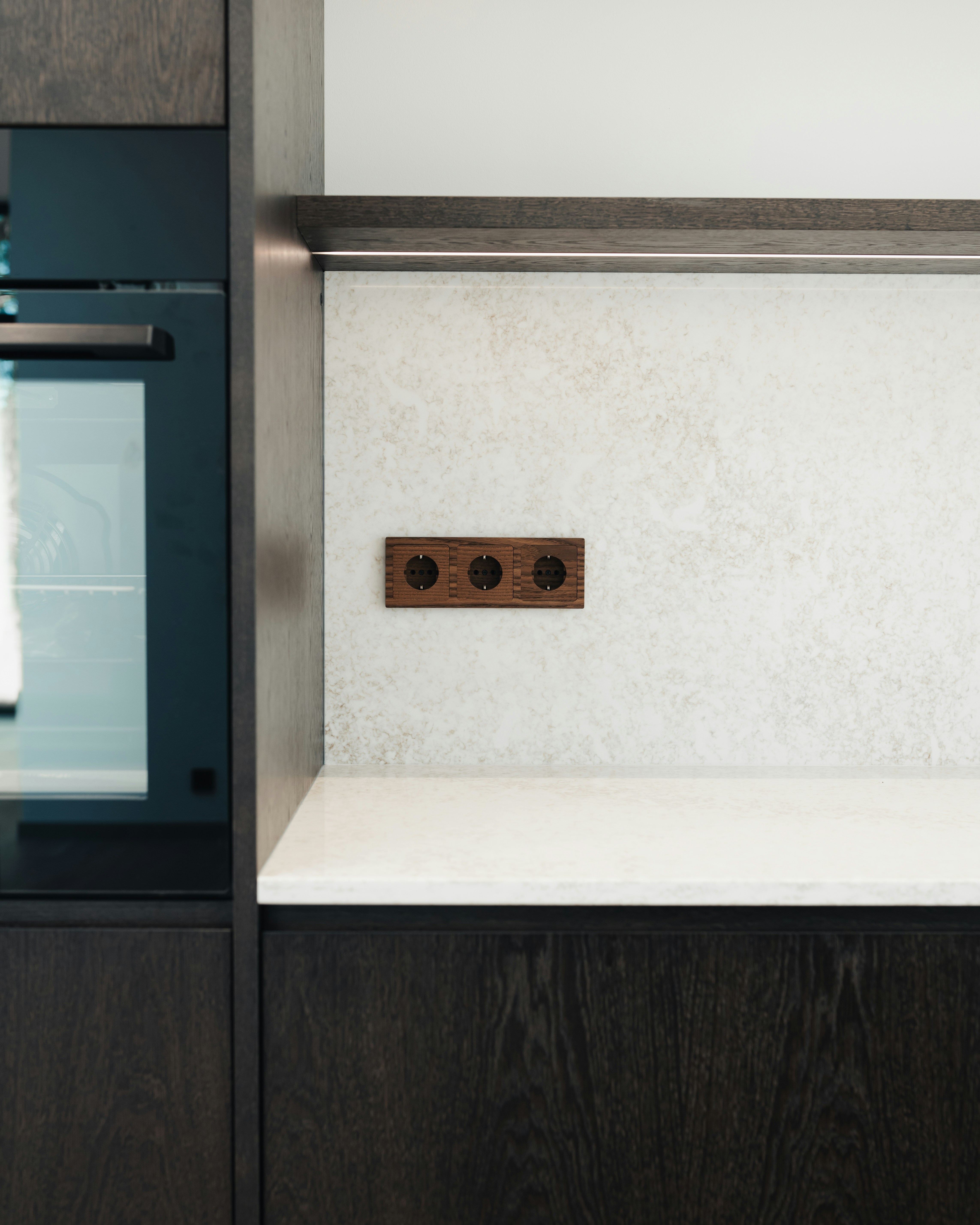 Modern kitchen with dark wood cabinets and white countertop