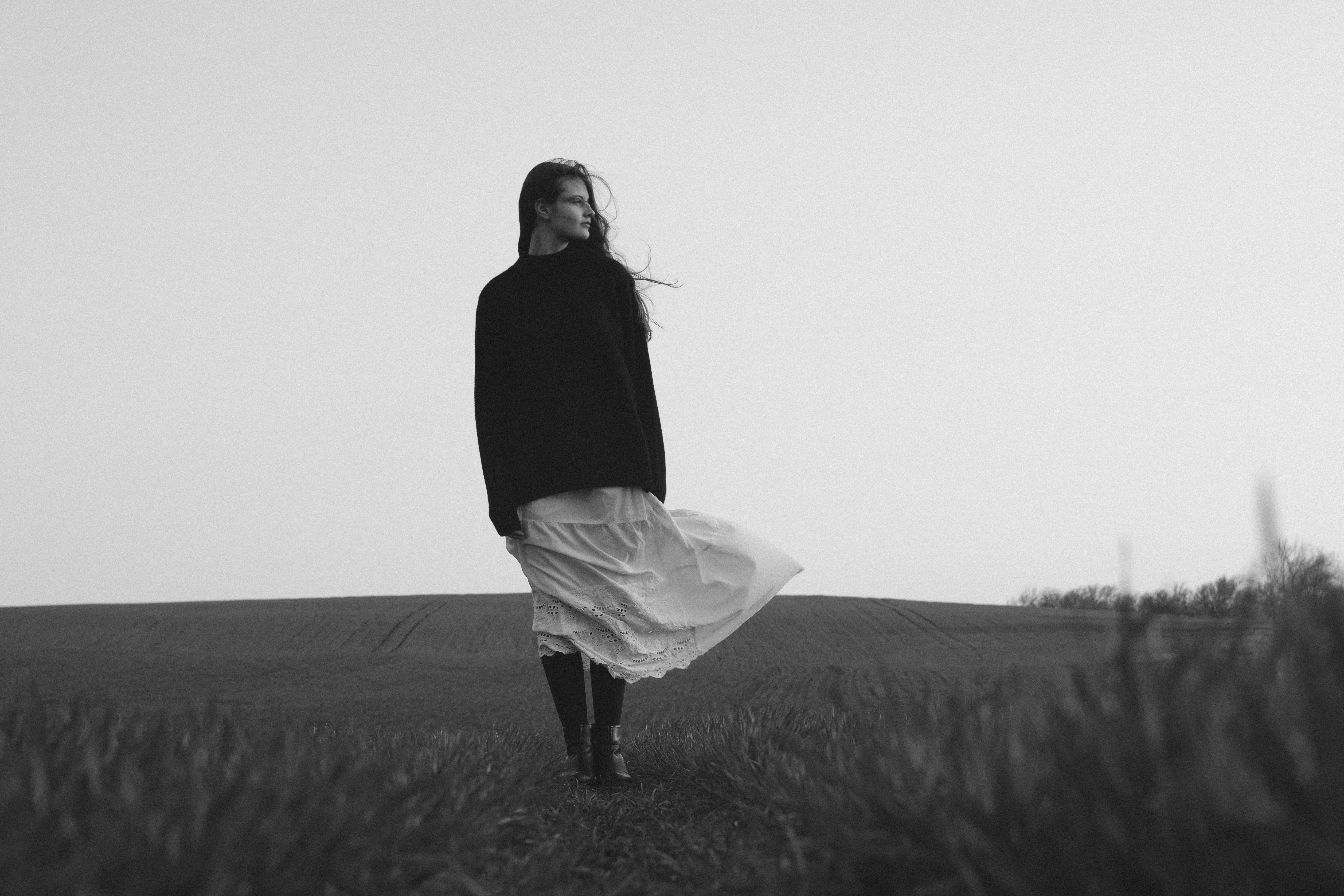 Woman in a flowing skirt walks through a field