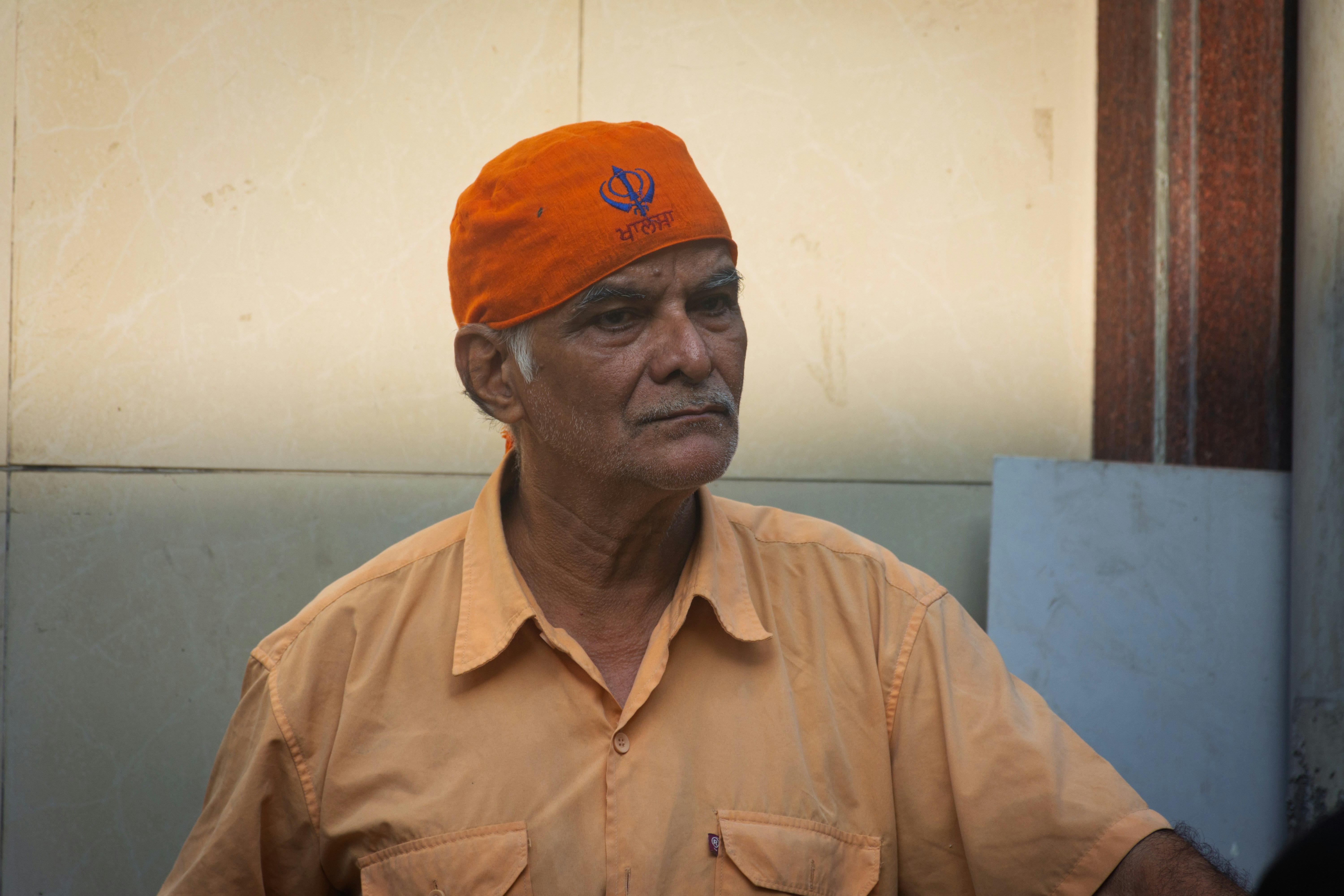 Elderly man wearing an orange turban and shirt