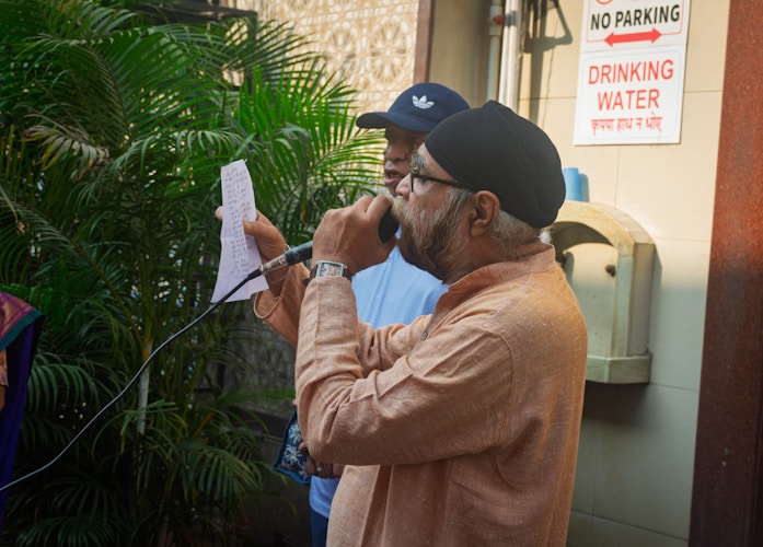 Speaker reading from paper into a microphone during a long-form recording session