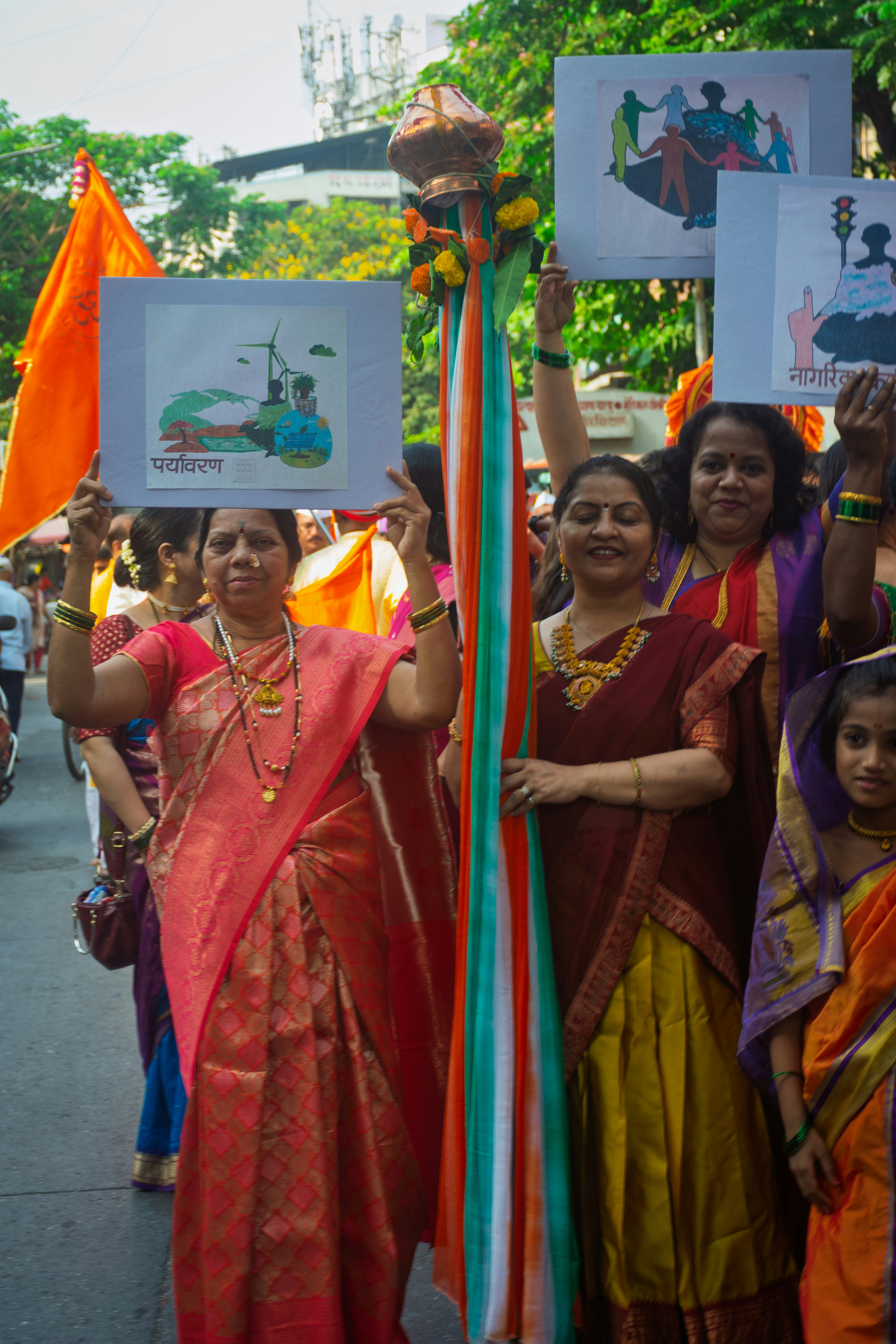 Mujeres con ropa tradicional sosteniendo pancartas durante un desfile.