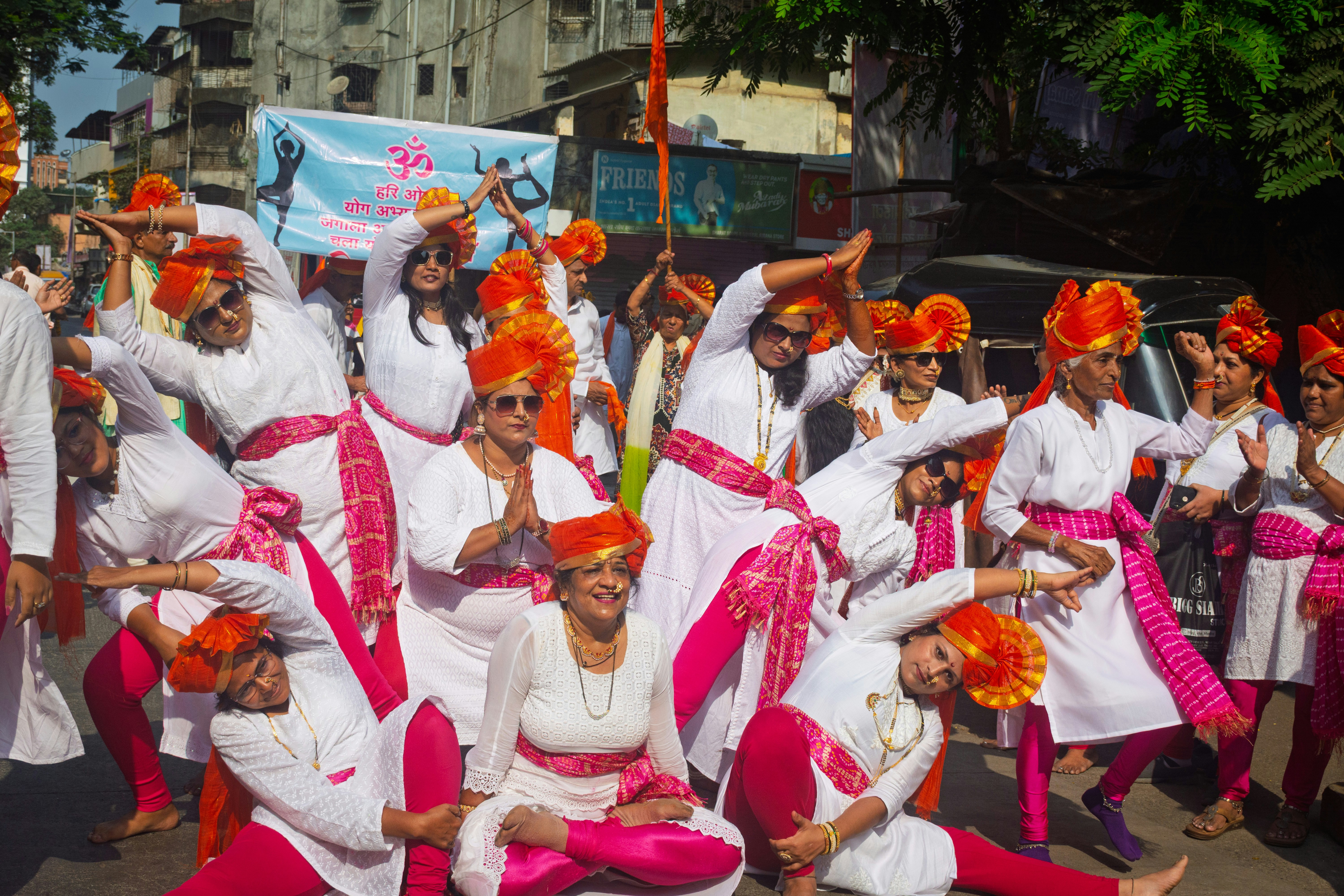 People in traditional indian attire dancing in a street parade.