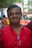 A smiling man in a red shirt with glasses